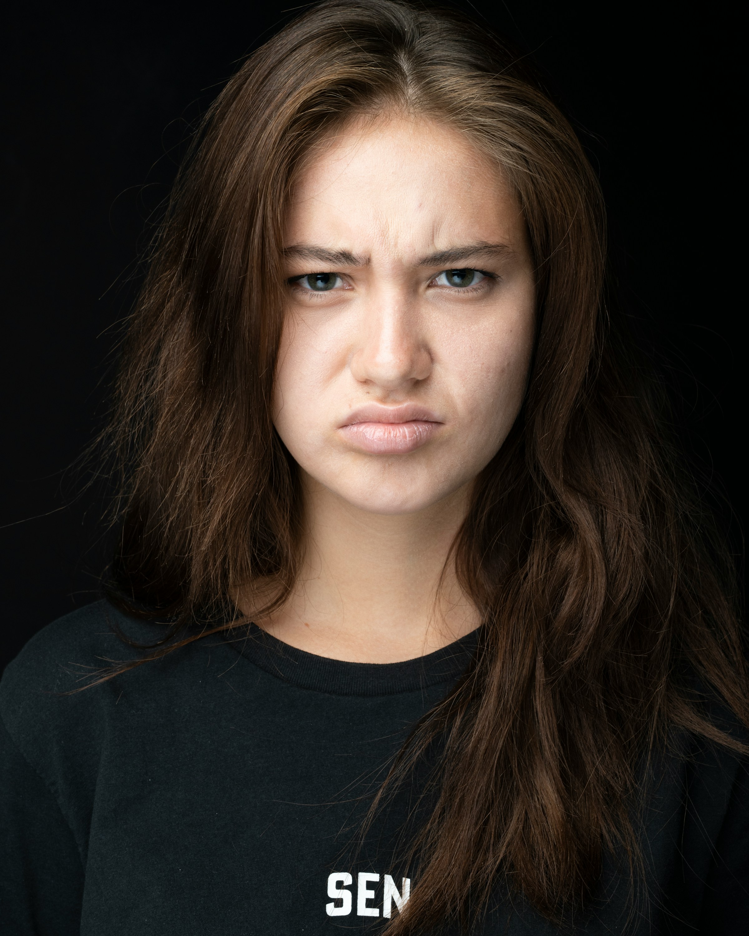 Eine stirnrunzelnde Frau in Schwarz | Quelle: Unsplash