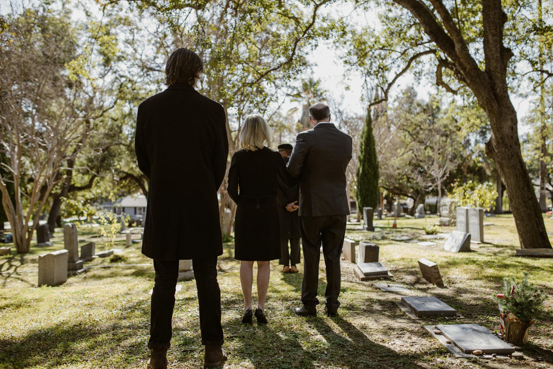 Menschen verlassen einen Friedhof | Quelle: Pexels