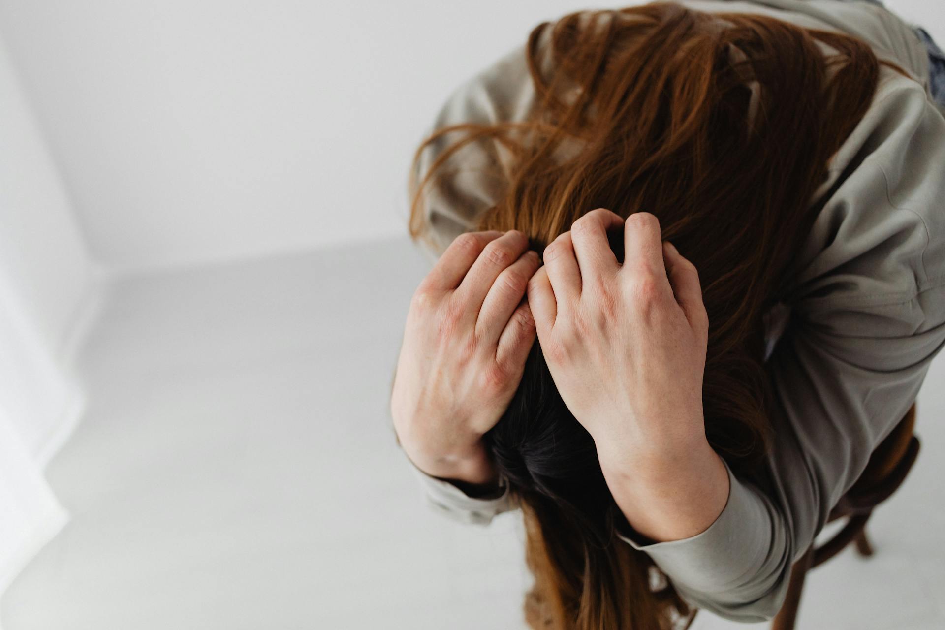 Eine Frau mit dem Kopf in ihren Händen | Quelle: Pexels