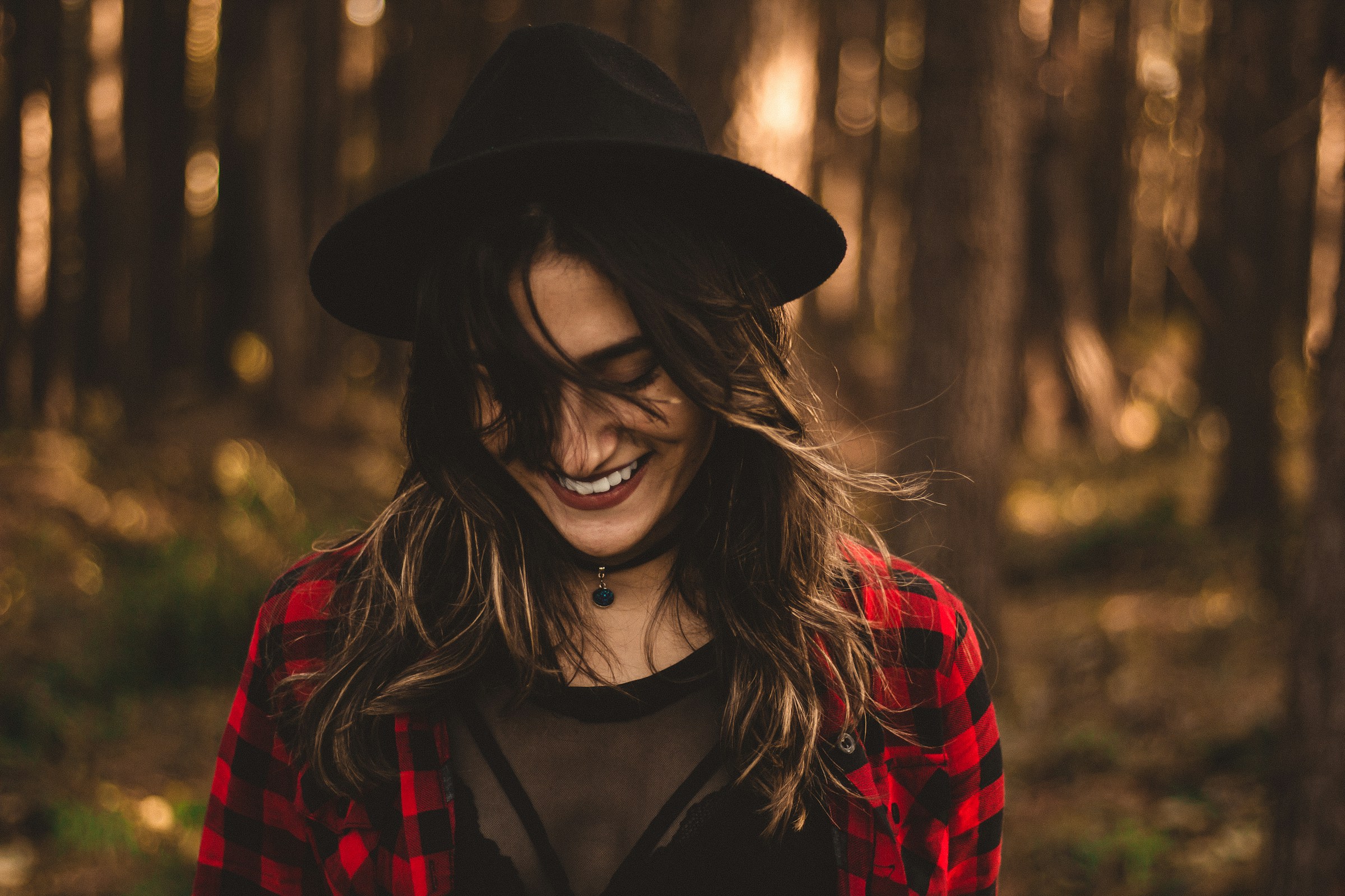 Eine lächelnde Frau im Wald | Quelle: Unsplash