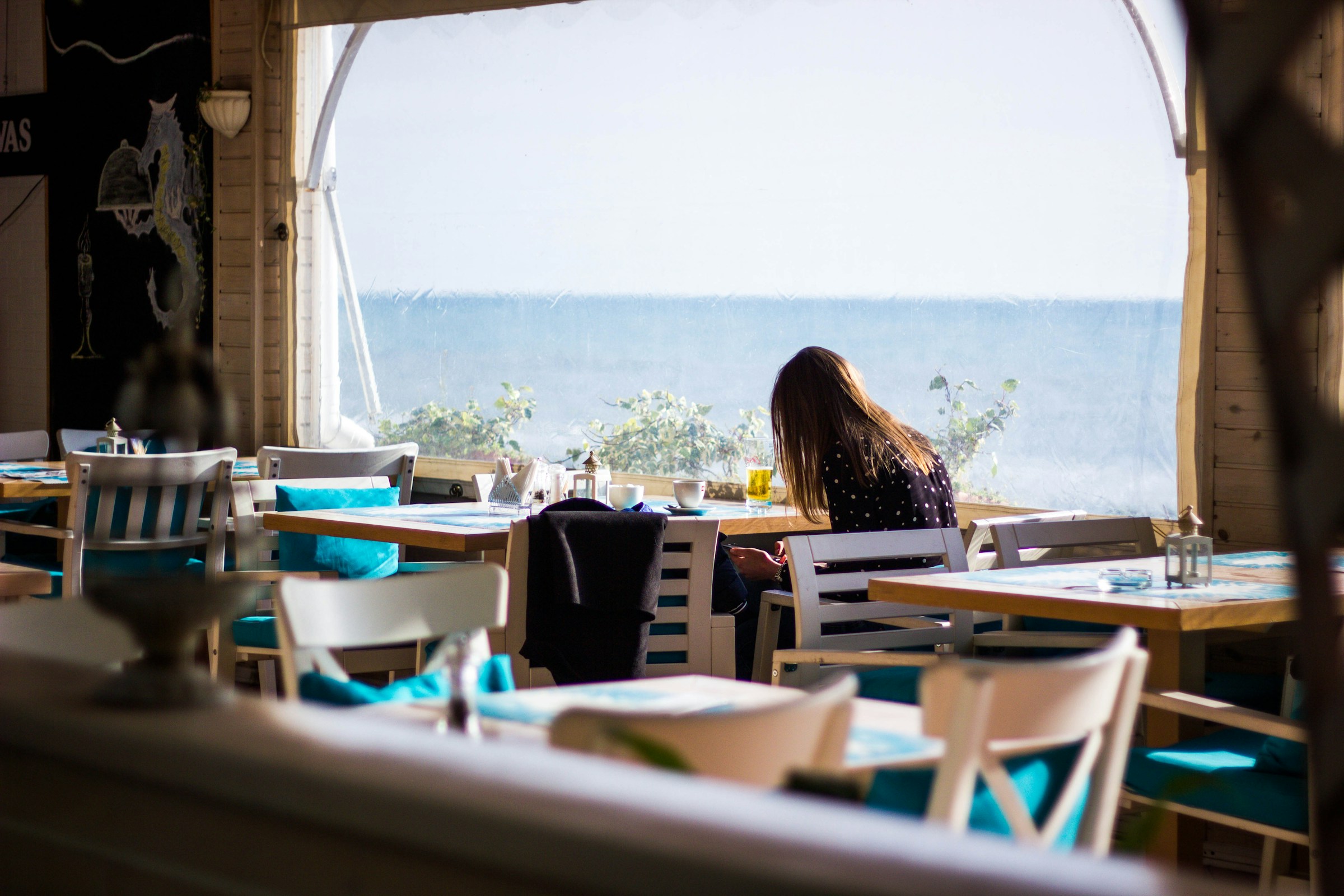 Nora wartet geduldig in einem Café darauf, dass sich ihr Plan entfaltet | Quelle: Unsplash