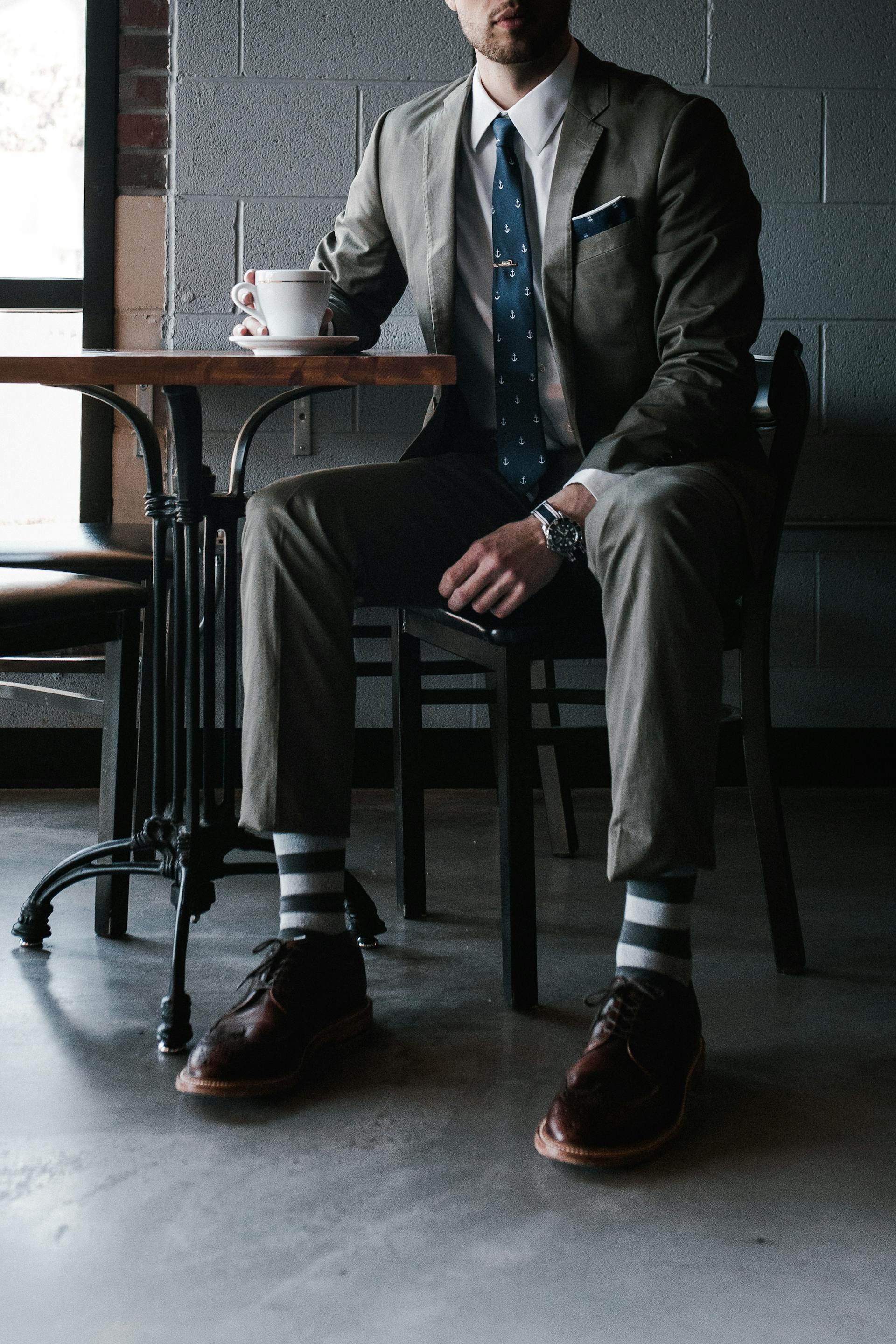 Ein Mann im Anzug sitzt an einem Tisch | Quelle: Pexels