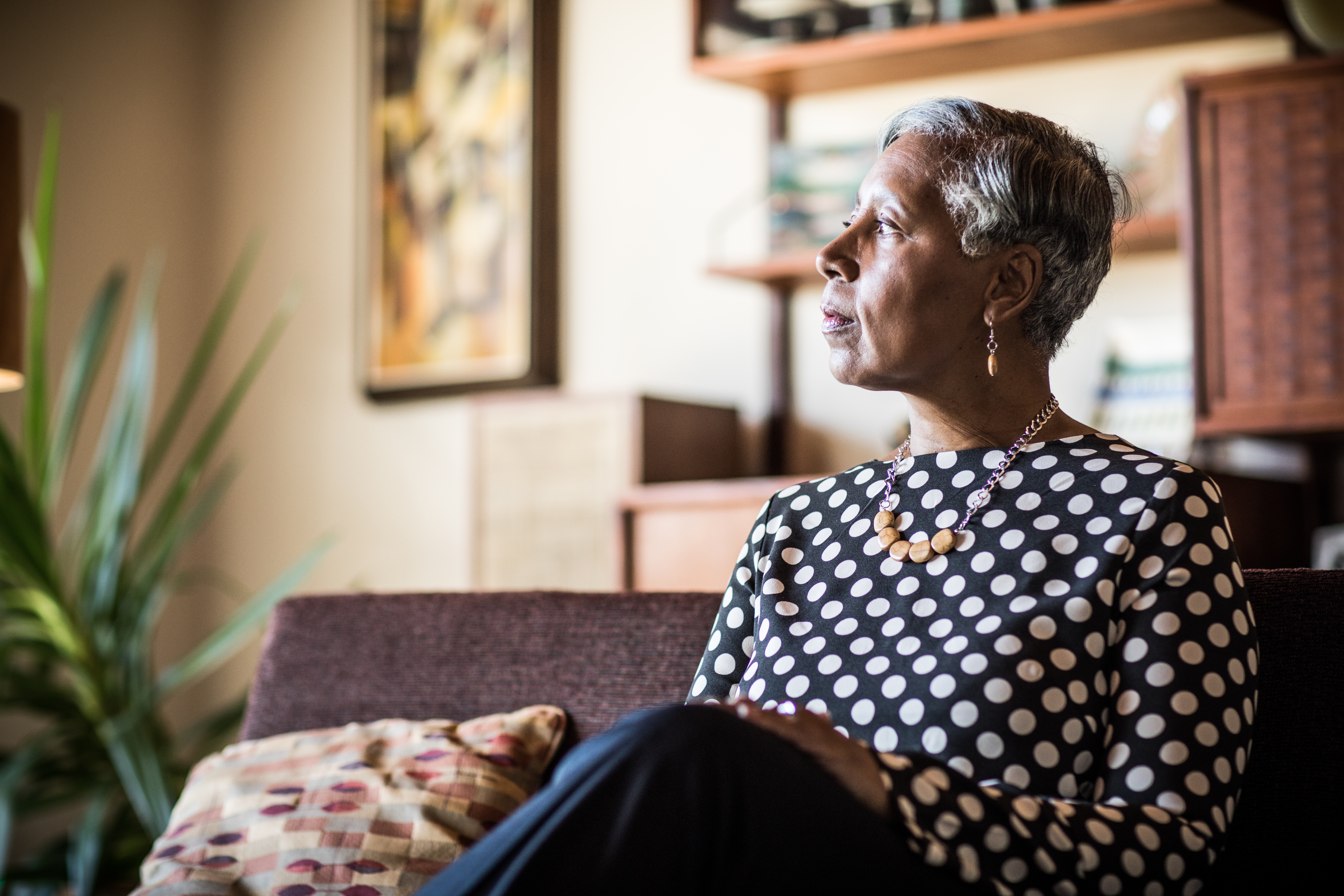 Porträt einer Frau (60 Jahre), die zu Hause auf der Couch sitzt | Quelle: Getty Images