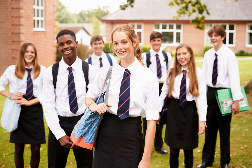 Schüler vor der Schule in Schuluniform. | Quelle: Shutterstock
