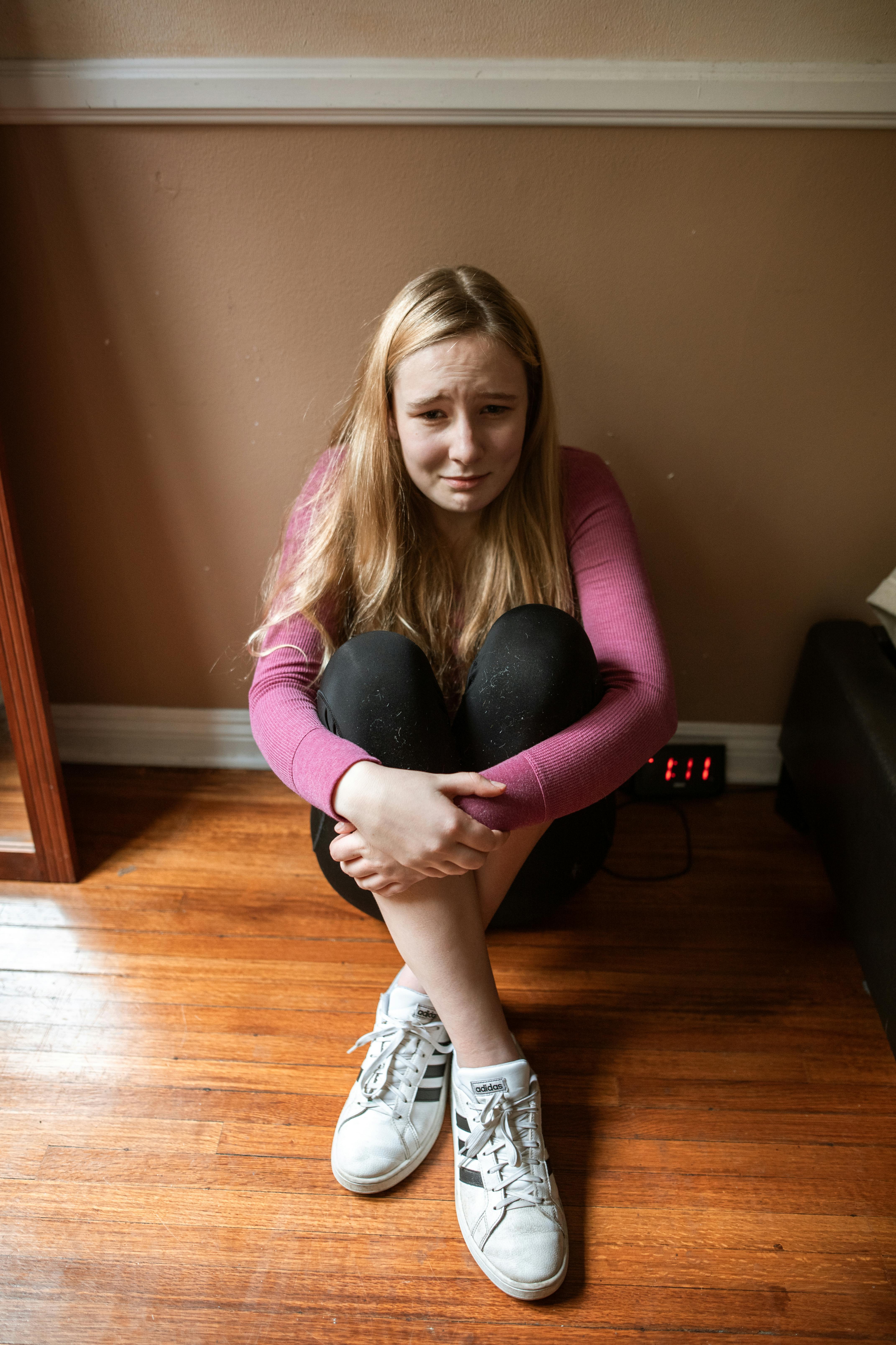Ein junges Mädchen, das auf dem Boden sitzt und weint | Quelle: Pexels