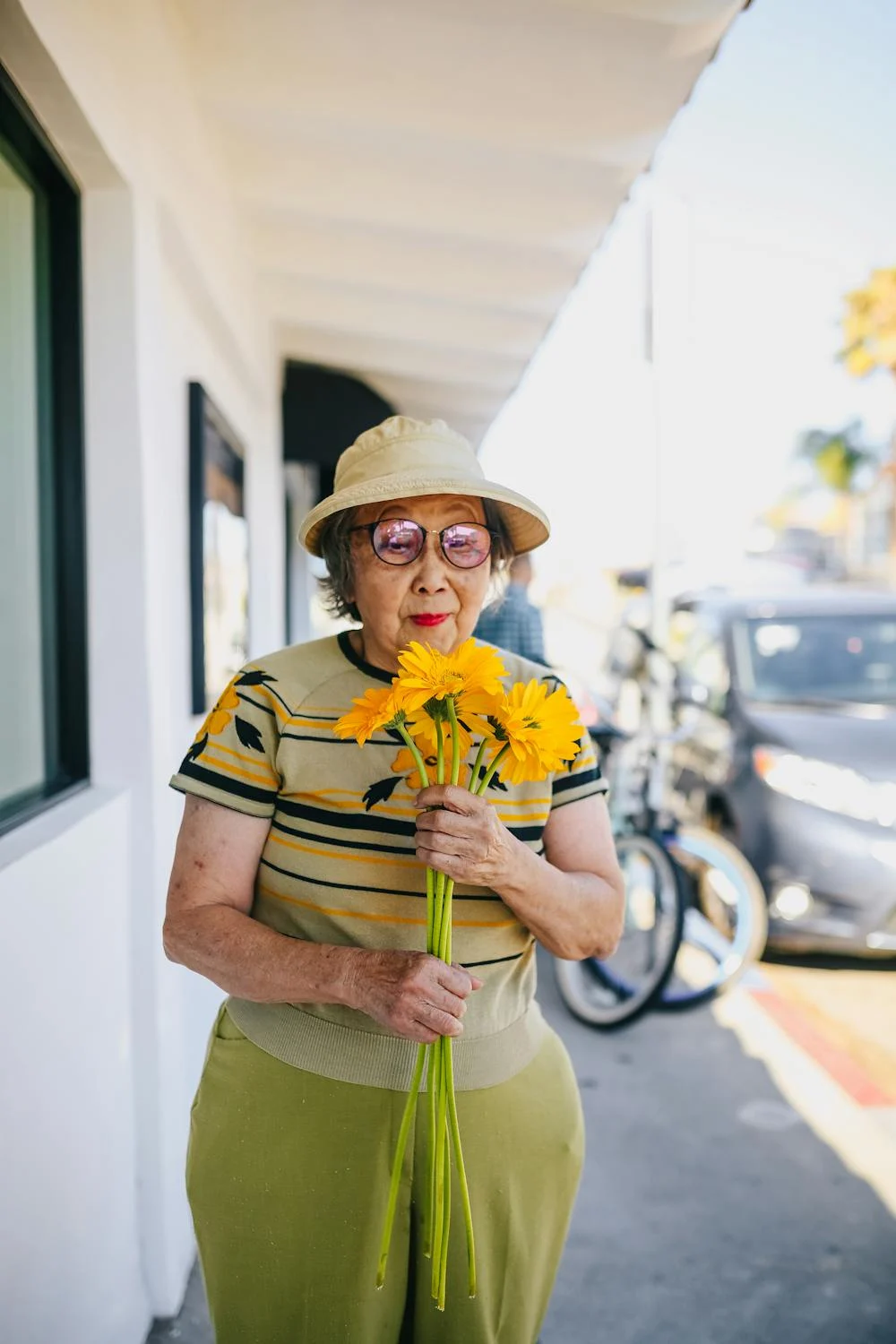 Eine lächelnde ältere Frau mit Blumen in der Hand | Quelle: Pexels