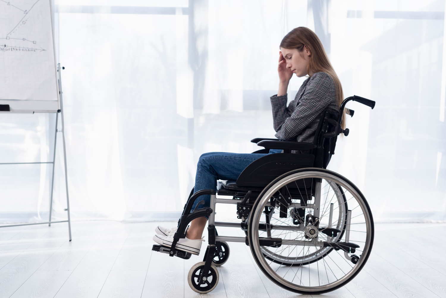 Eine verzweifelte Frau, die in einem Rollstuhl sitzt | Quelle: Freepik