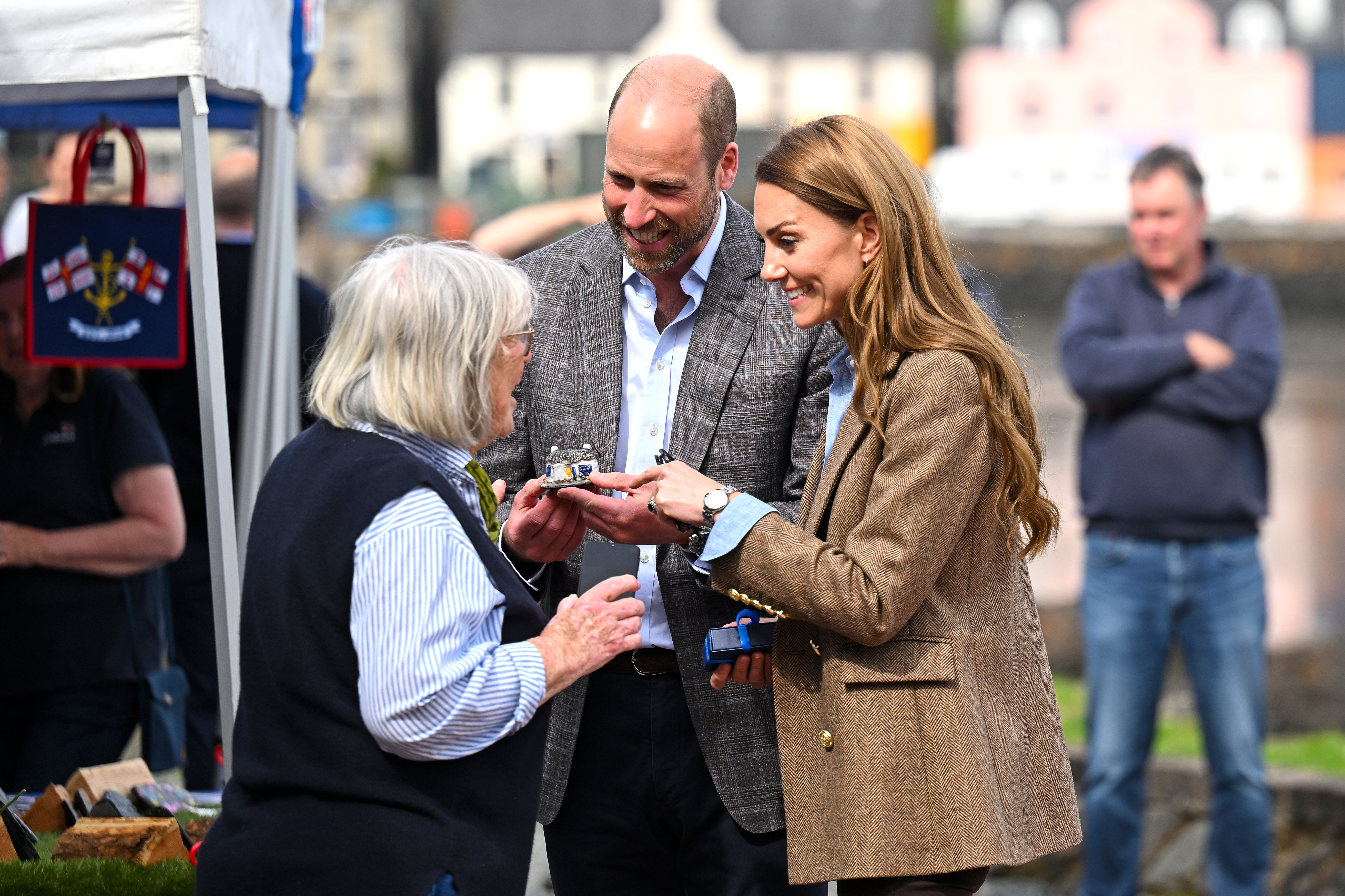 William und Catherine unterhalten sich während ihres Rundgangs in Tobermory mit einem lokalen Markthändler. Bei ihrem Besuch auf der Isle of Mull ging es vor allem darum, kleine Unternehmen zu unterstützen und sich für die Umweltarbeit der Gemeinde zu engagieren.