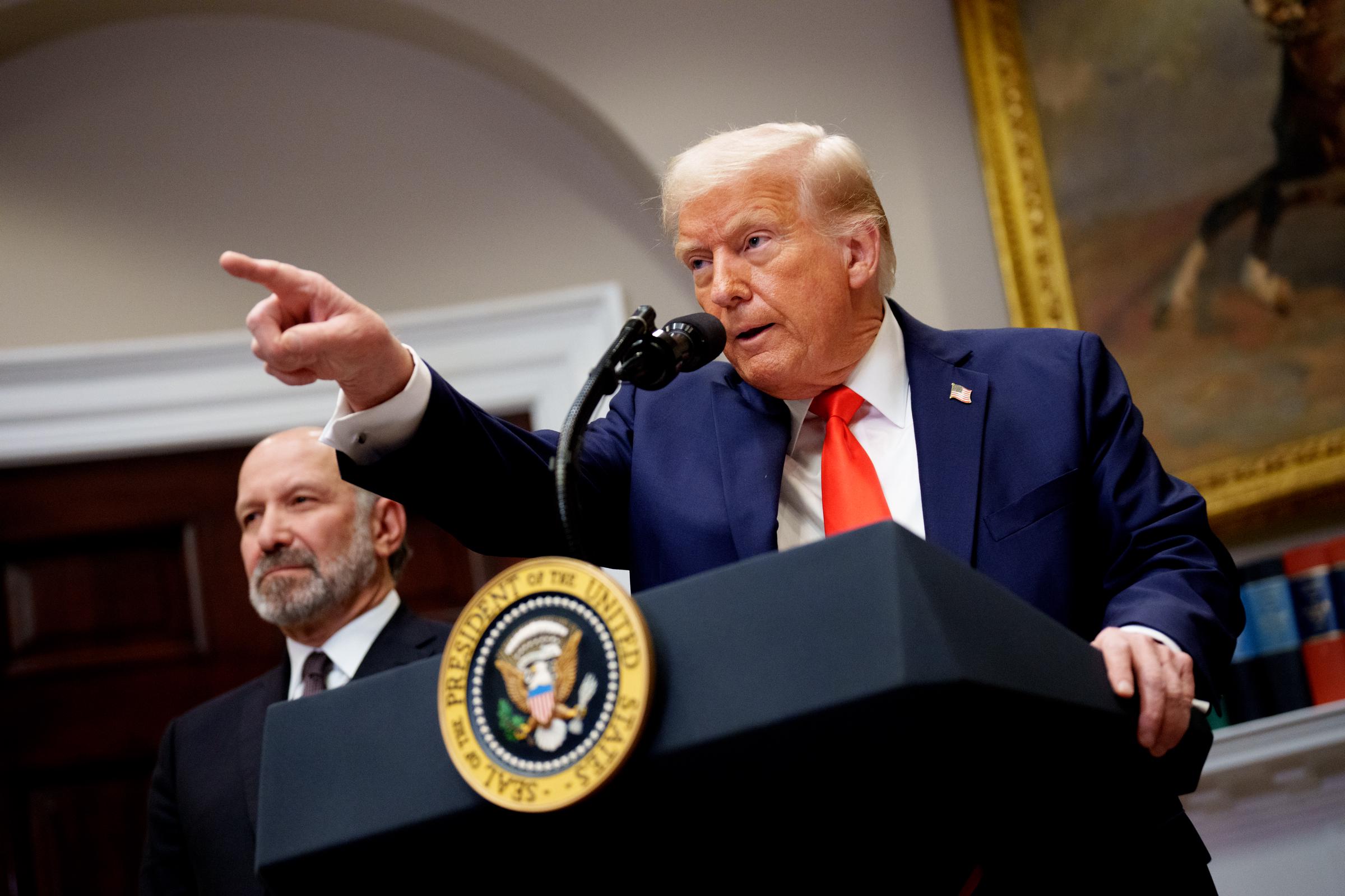 US-Präsident Donald Trump, begleitet von Handelsminister Howard Lutnick (L), stellt sich der Frage eines Reporters im Roosevelt Room des Weißen Hauses am 3. März 2025 in Washington, D.C. | Quelle: Getty Images