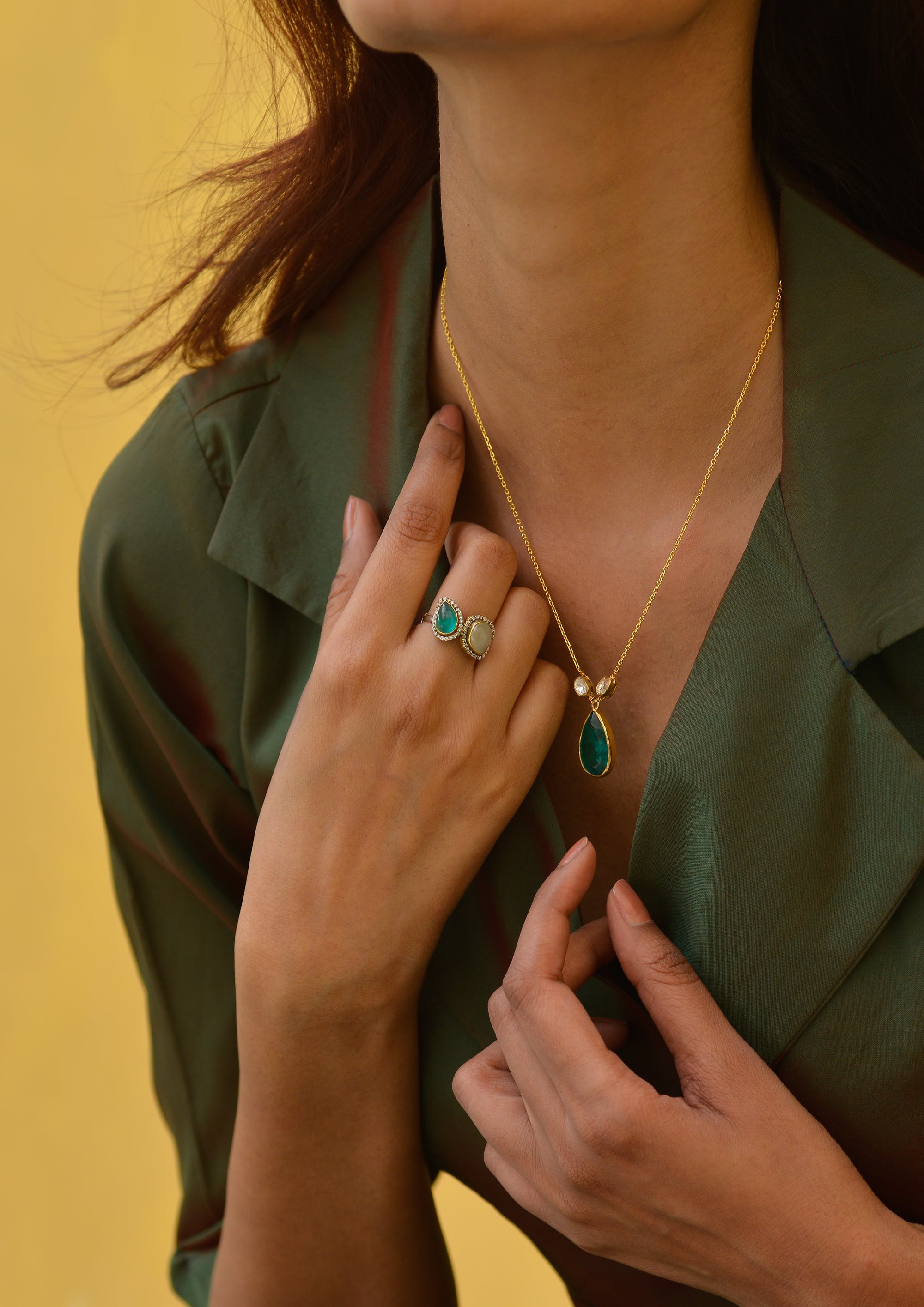 Eine Frau trägt einen Smaragd-Anhänger und einen Ring | Quelle: Pexels