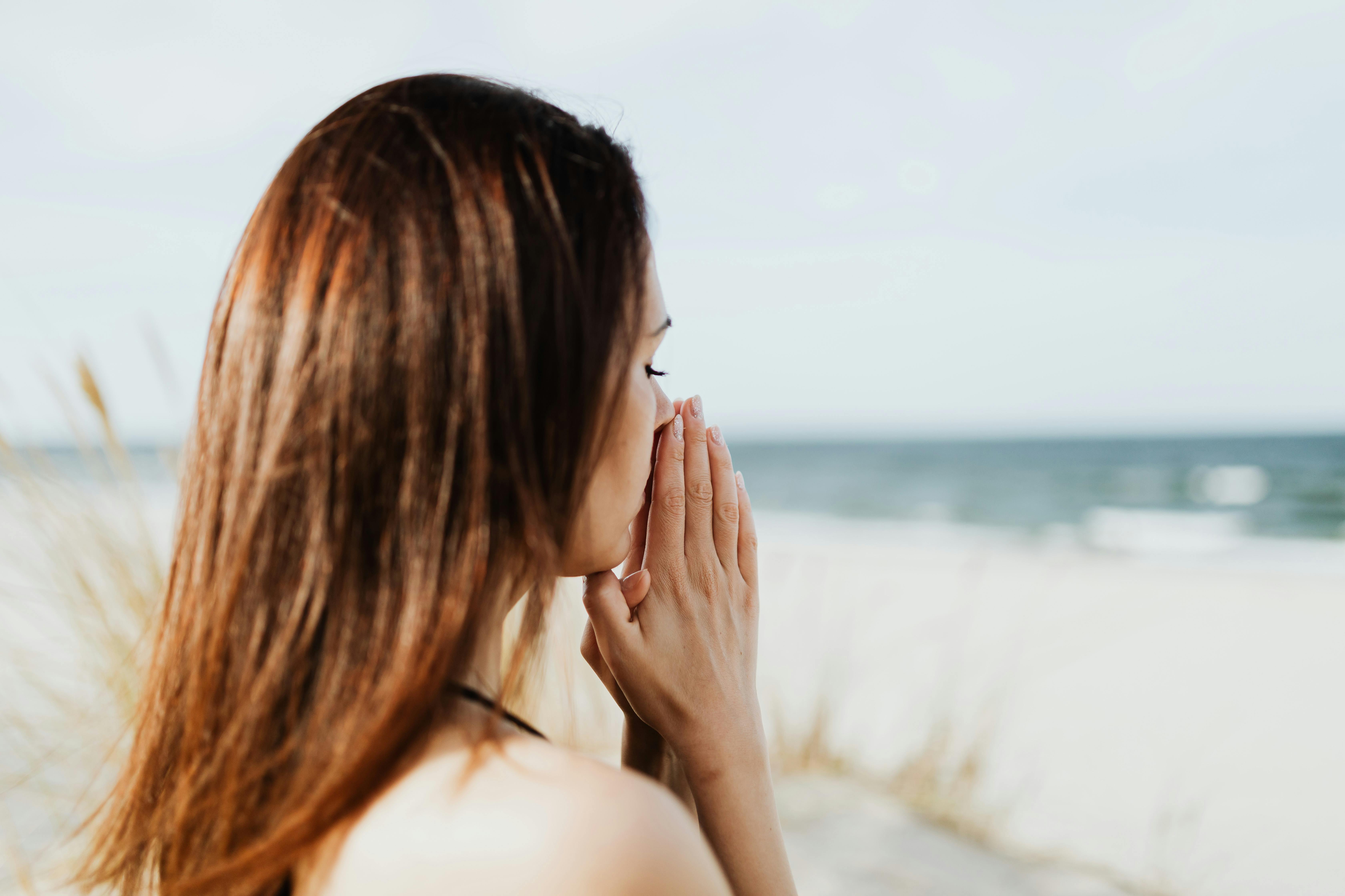 Mulher esperançosa na praia | Fonte: Pexels