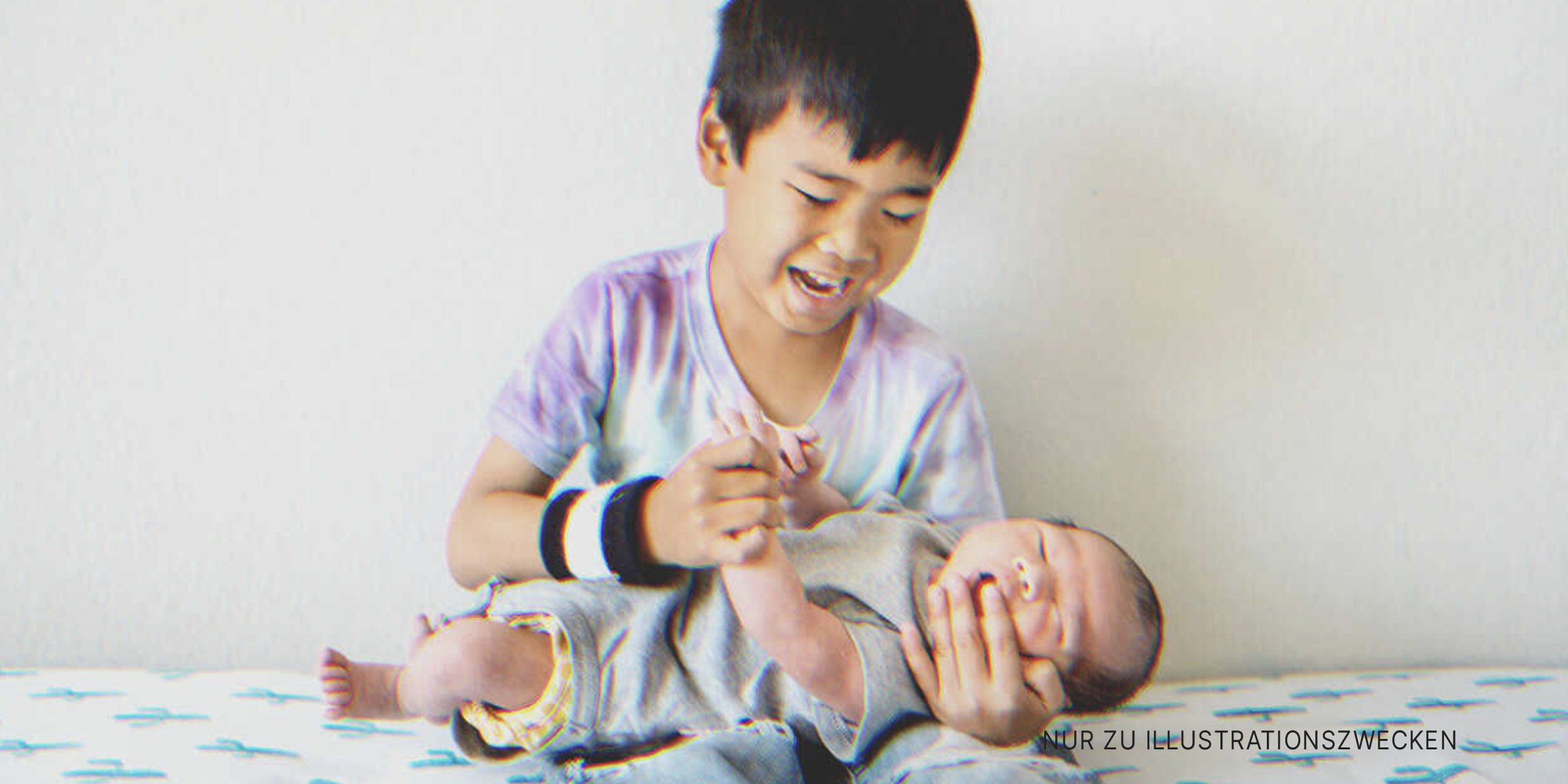 Ein Junge hält ein Baby | Quelle: Shutterstock