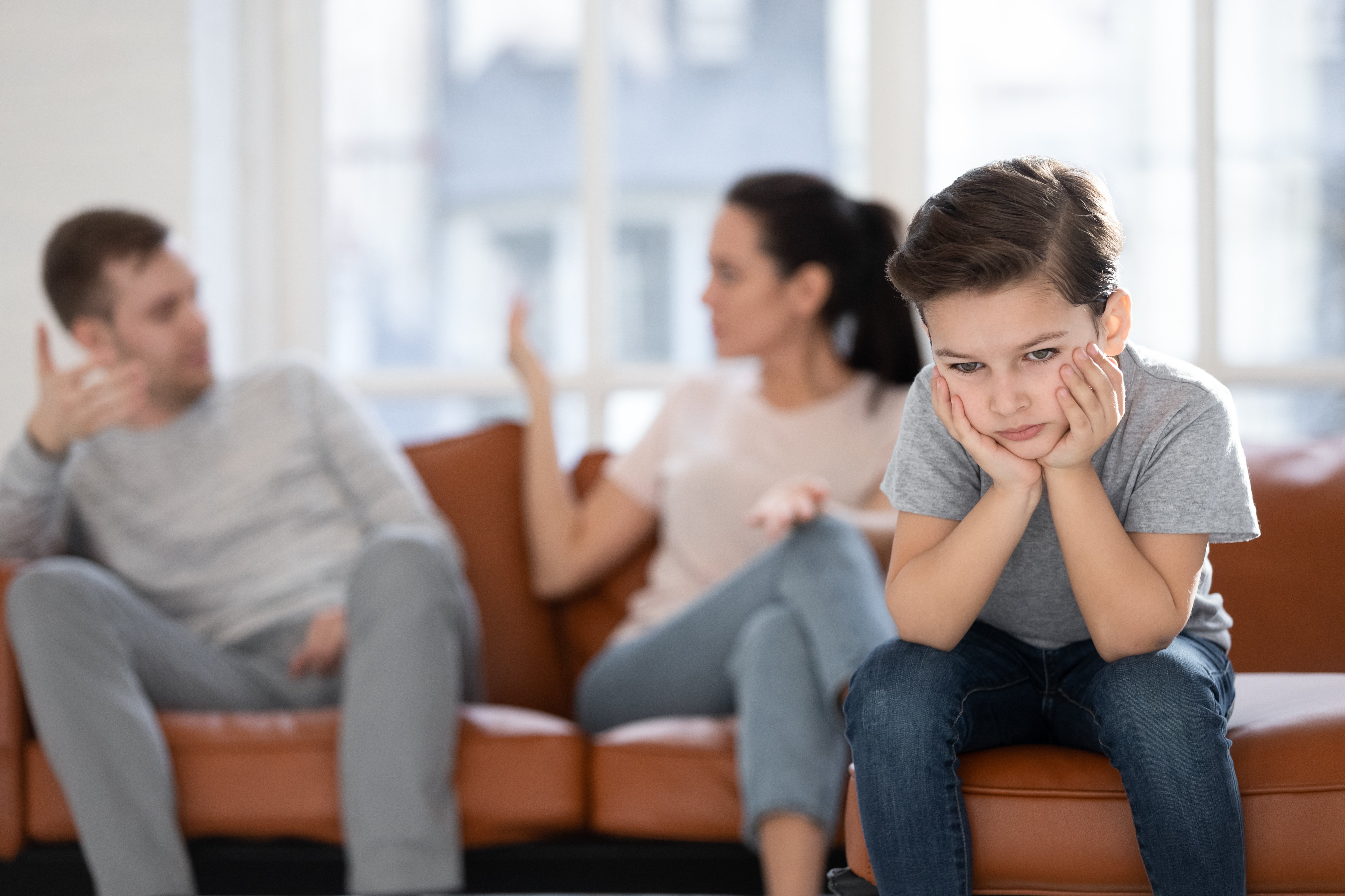 Kleiner Junge sitzt, während Eltern sich streiten | Quelle: Shutterstock