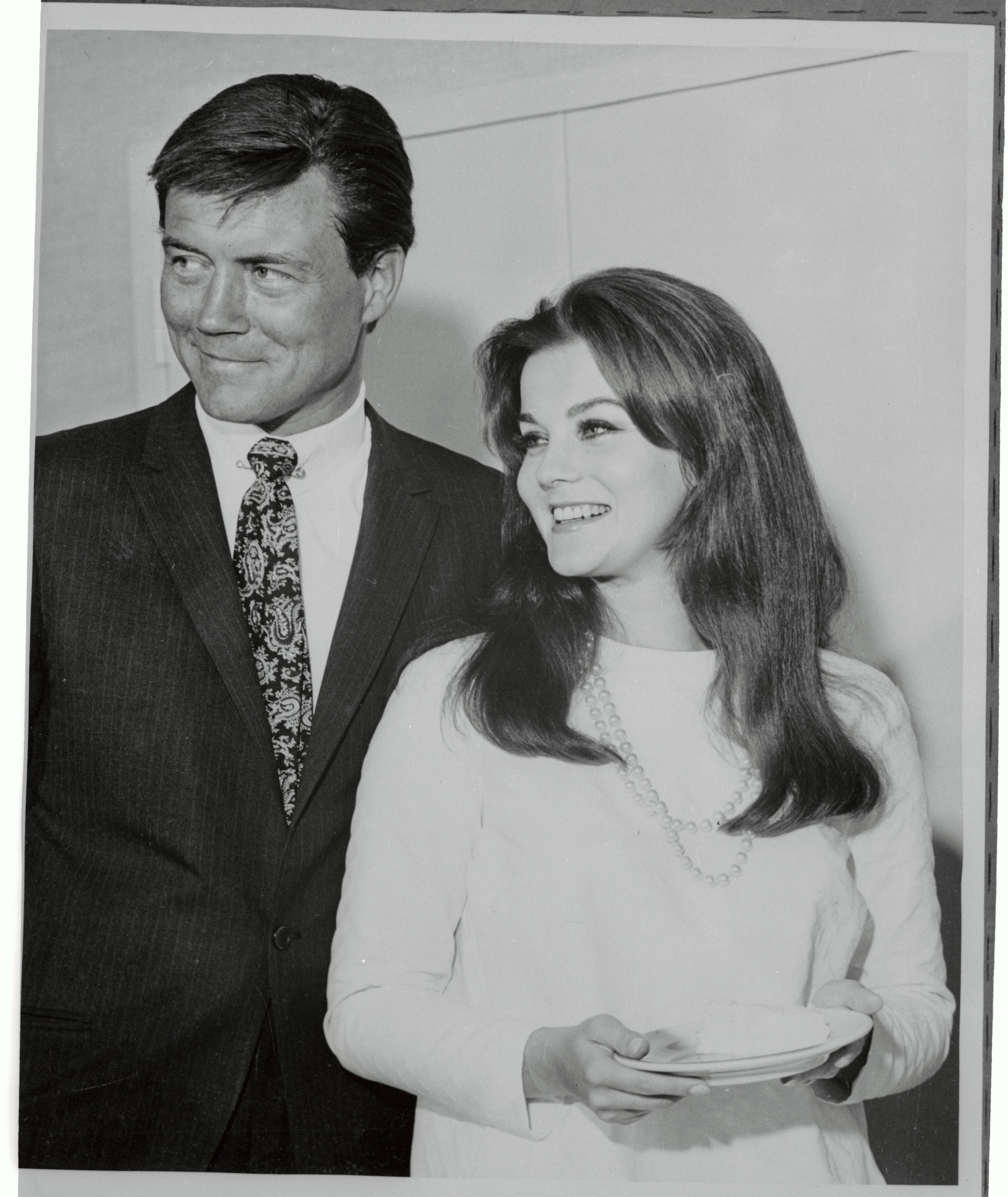 Ann-Margret hält ein Stück Hochzeitstorte, während sie neben ihrem neuen Mann Roger Smith steht, nachdem sie am 8. Mai 1967 standesamtlich geheiratet haben. | Quelle: Getty Images