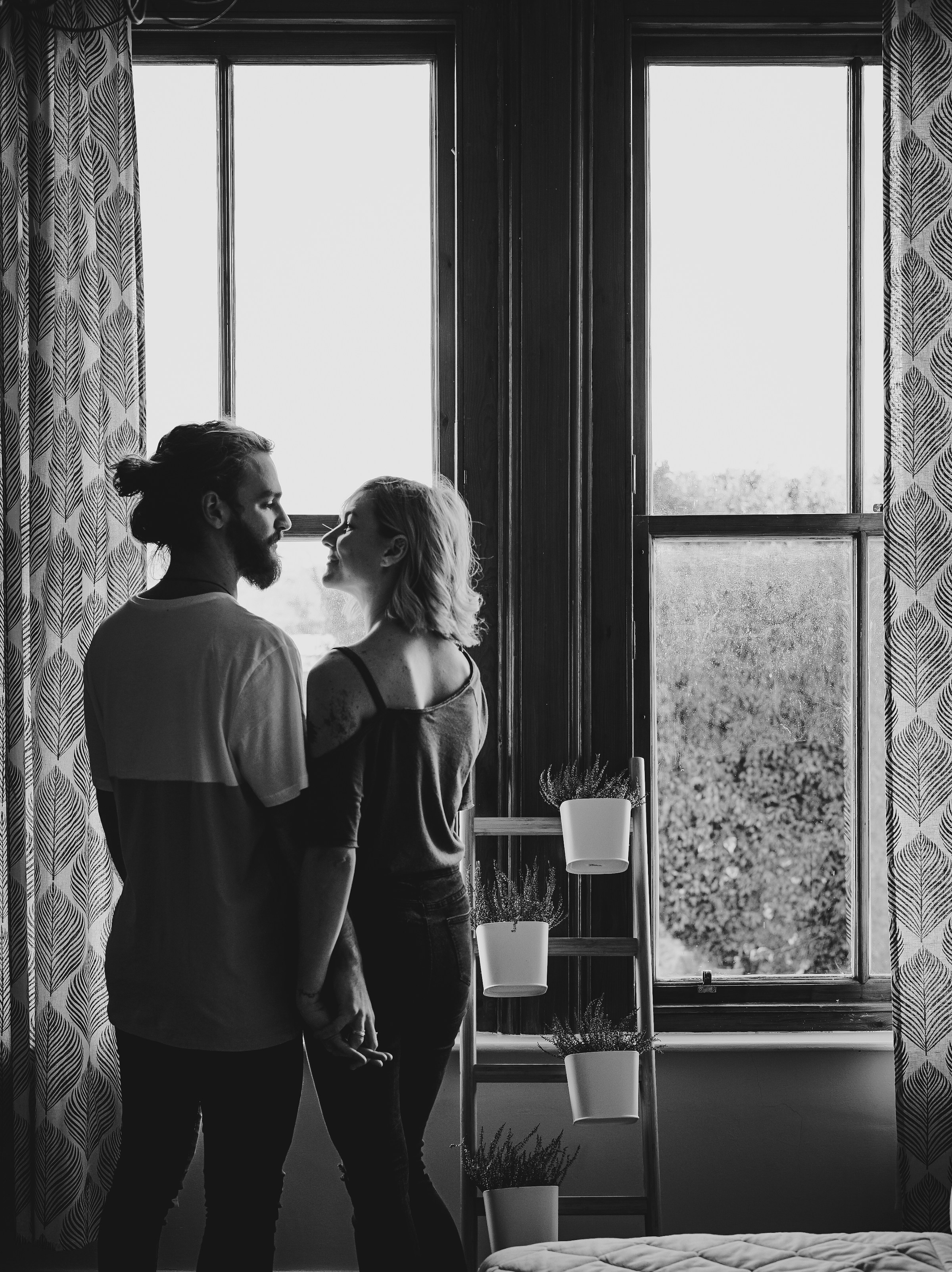 Ein lächelndes Paar, das an einem Fenster steht | Quelle: Unsplash