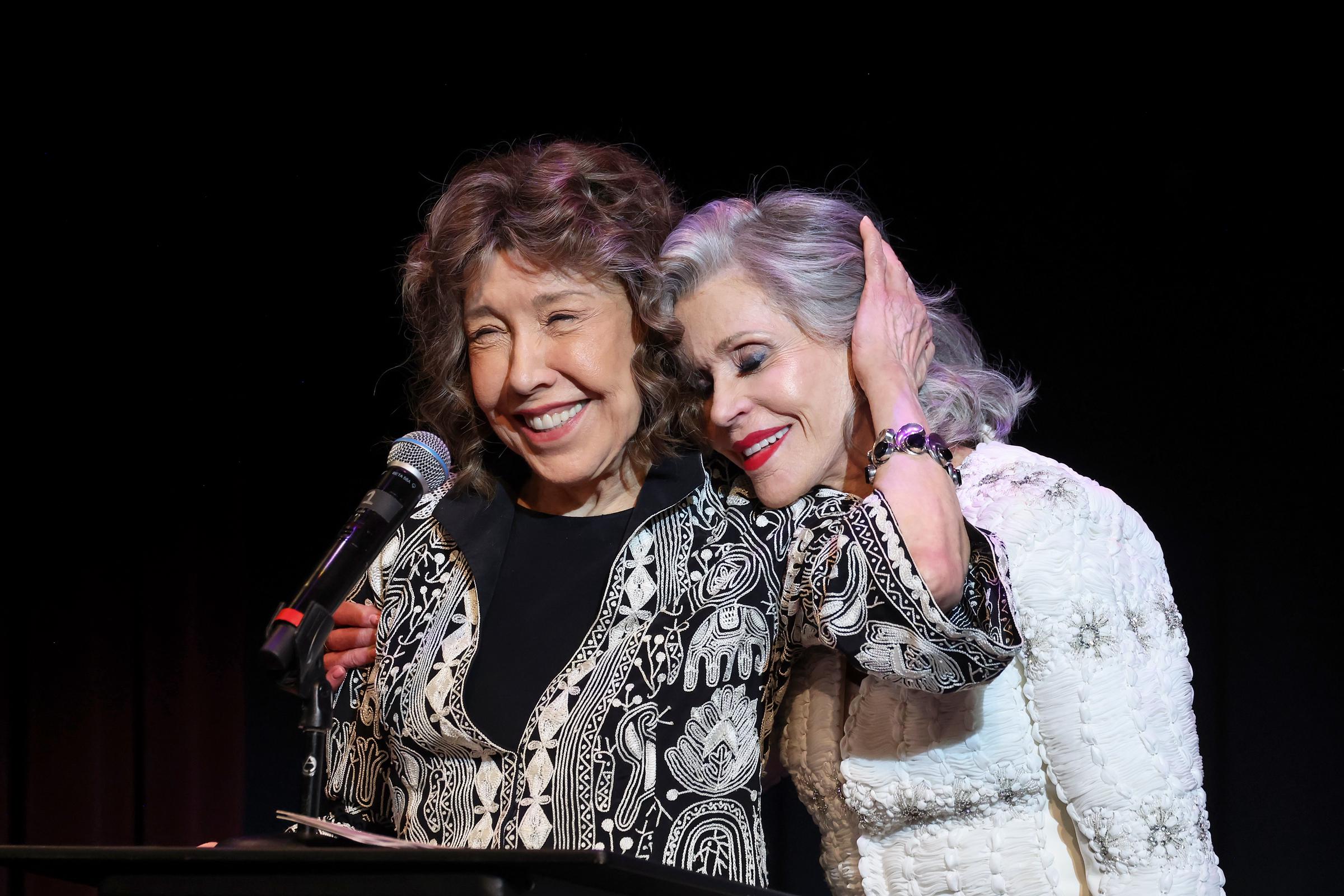 Lily Tomlin und Jane Fonda sprechen auf der Bühne während der Era Coalition Forward Women's Equality Trailblazer Awards und der Premiere von "Still Working 9 to 5" im Lily Tomlin/Jane Wagner Cultural Arts Center am 29. Mai 2024 in Los Angeles, Kalifornien. | Source: Getty Images