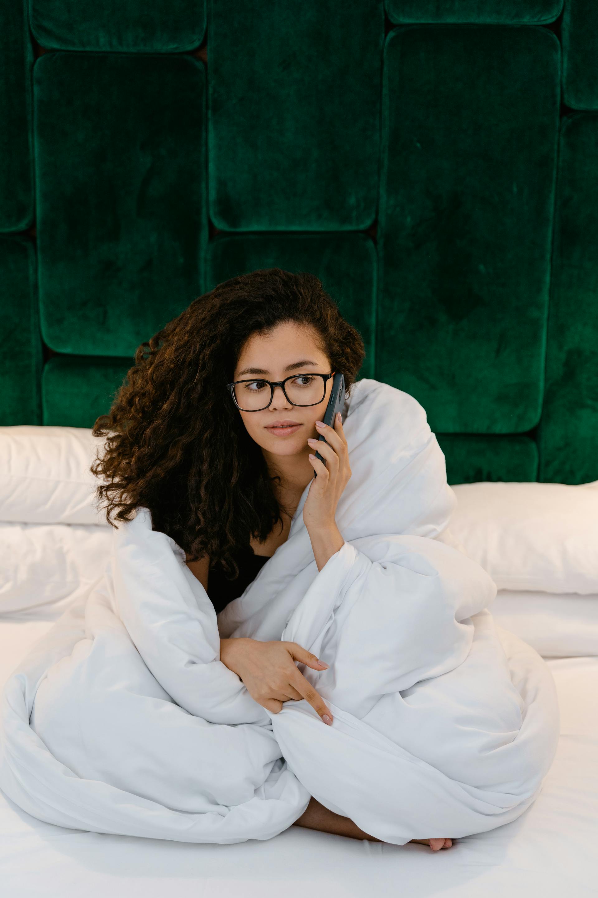 Eine Frau im Bett, die einen Telefonanruf entgegennimmt | Quelle: Pexels