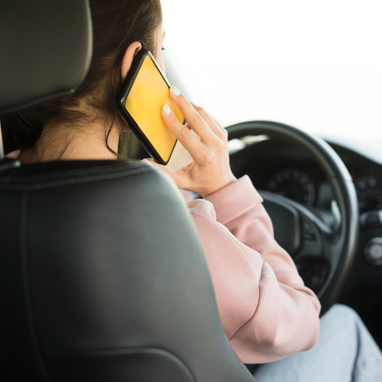 Eine Frau telefoniert, während sie hinter dem Steuer sitzt | Quelle: Freepik