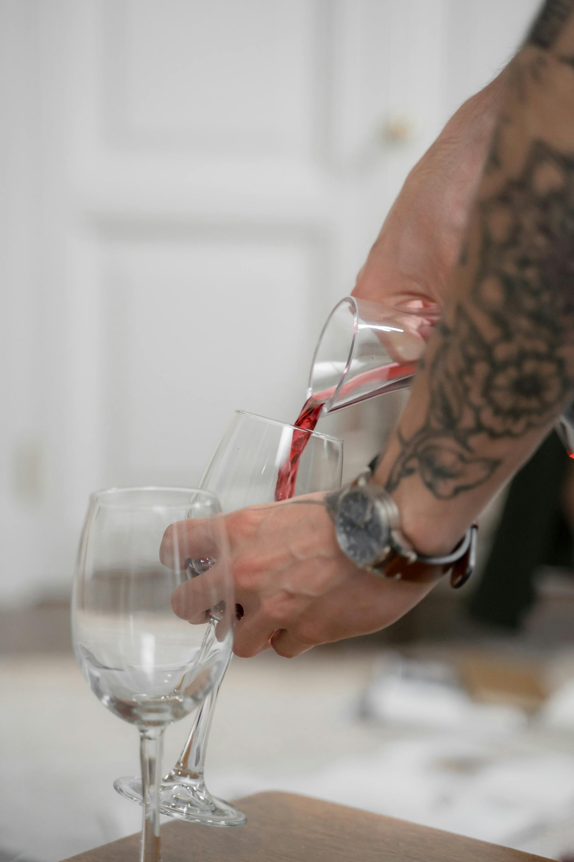 Ein Mann schenkt Wein in ein Glas ein | Quelle: Pexels