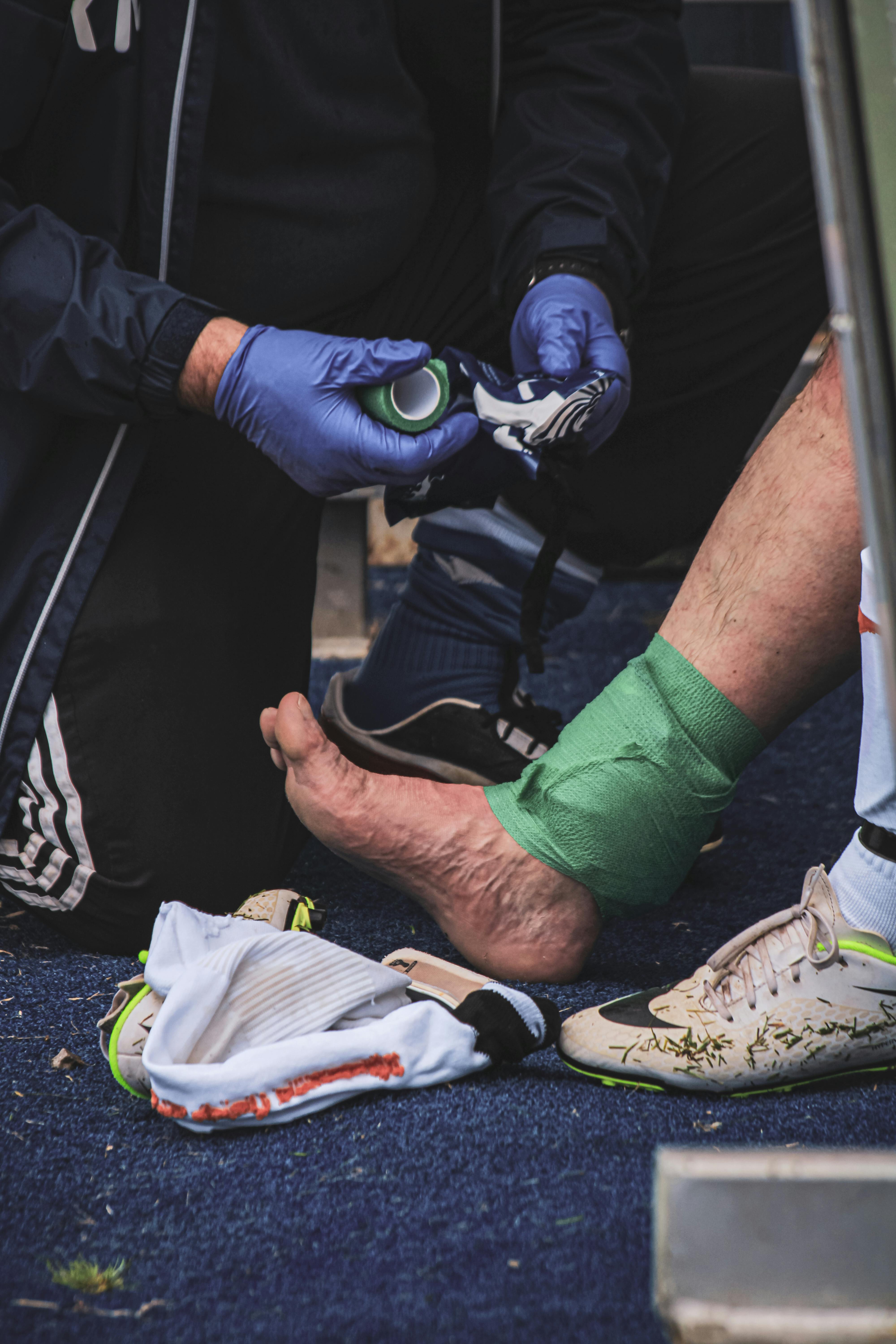 Ein Mann hilft einem Spieler bei einer Verletzung. | Quelle: Pexels