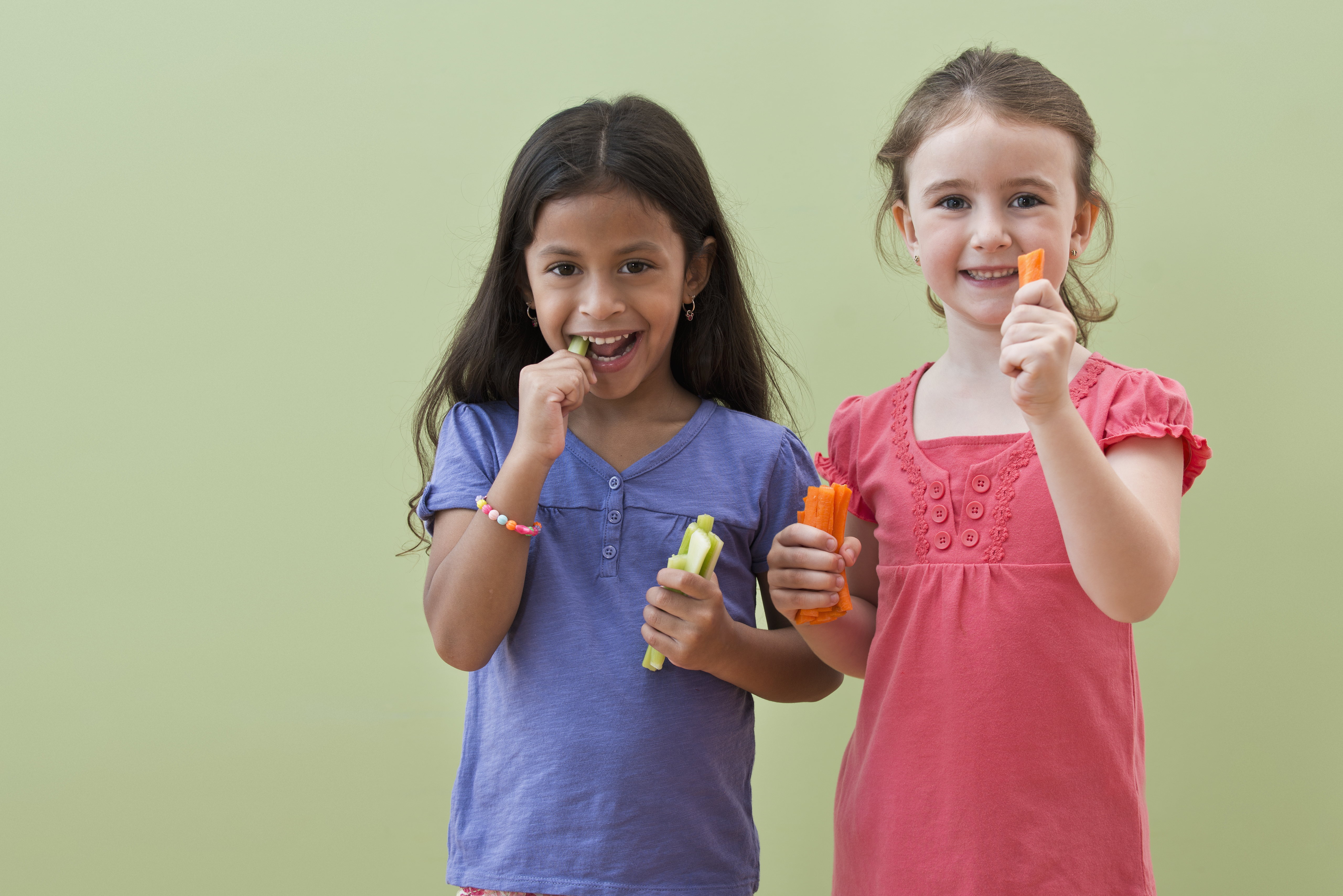 Mädchen essen gemeinsam Gemüsesticks | Quelle: Getty Images