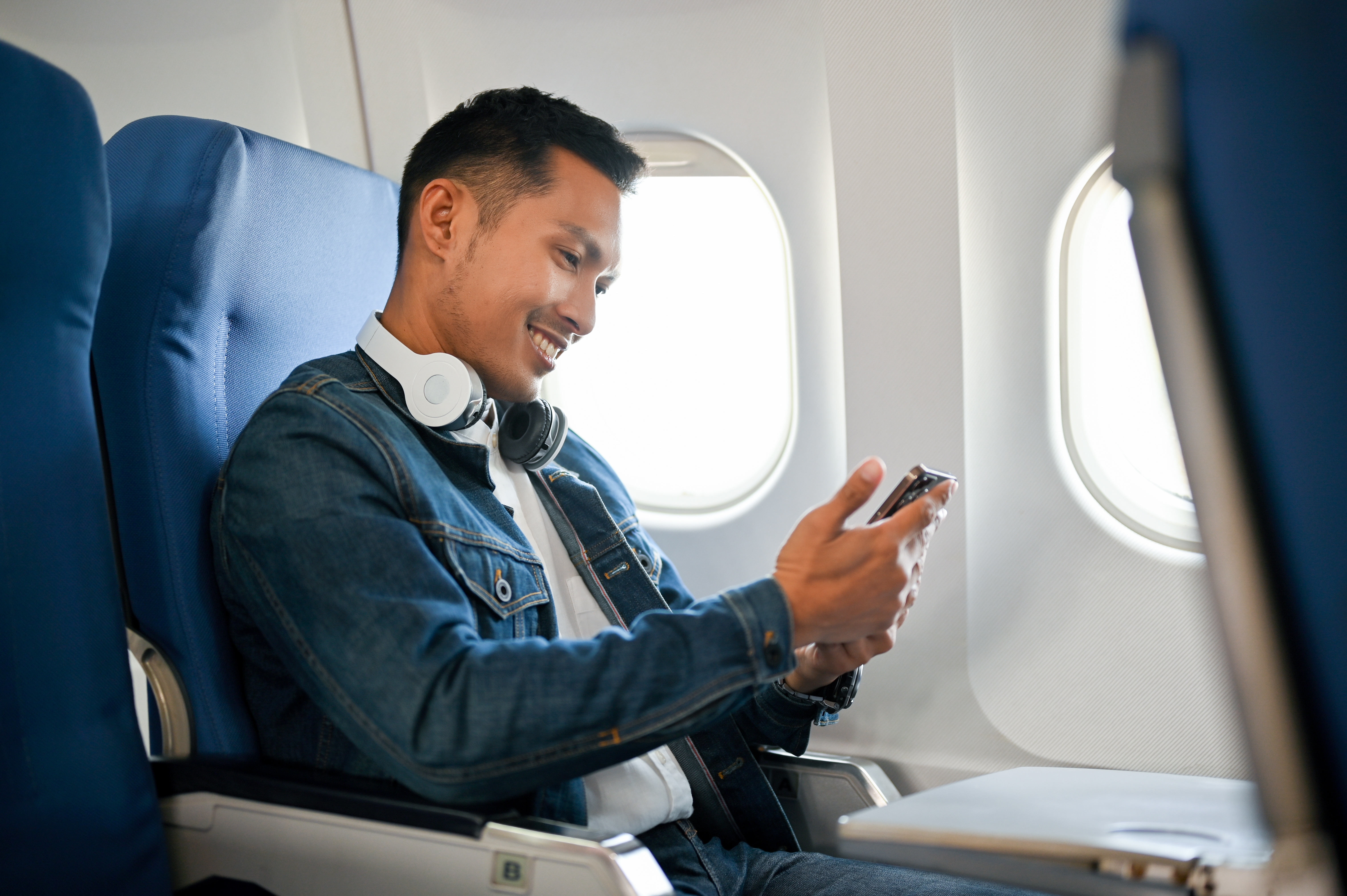 Junger Mann in einem Flugzeug | Quelle: Shutterstock