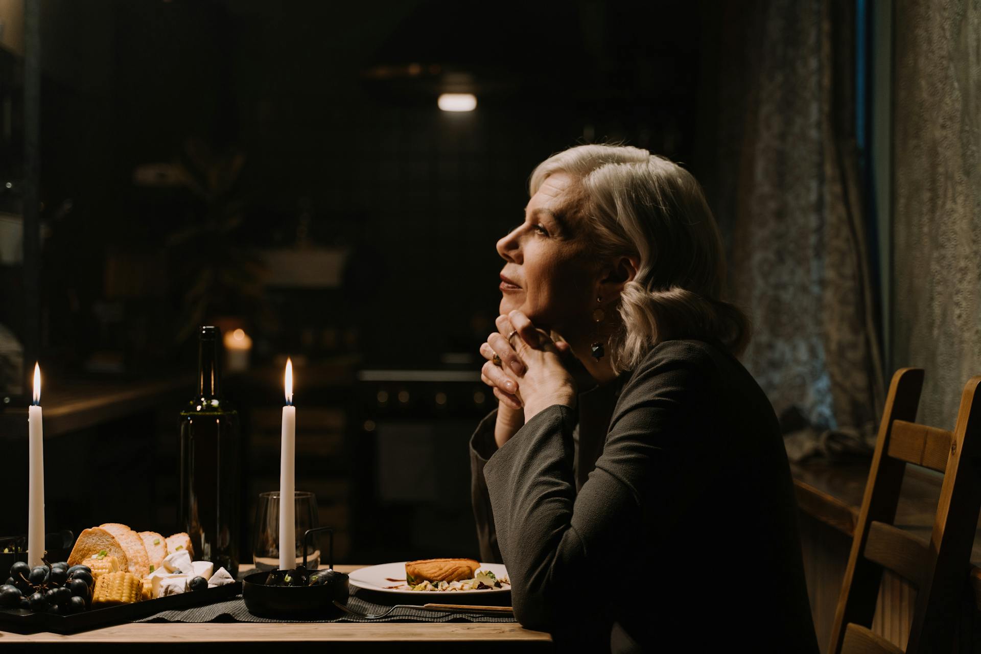 Eine elegante ältere Frau, die an einem Esstisch sitzt | Quelle: Pexels