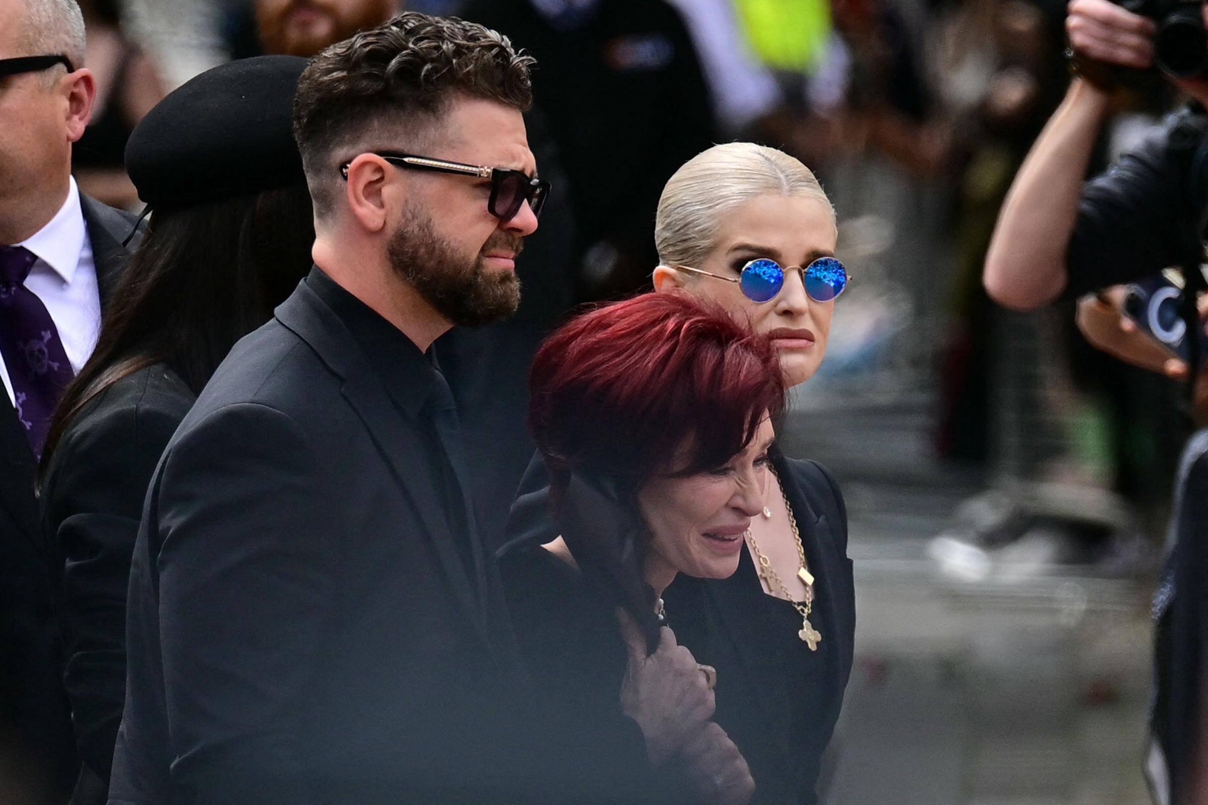 Sharon, Jack und Kelly Osbourne legen während des Trauerzuges für Ozzy am 30. Juli 2025 in Birmingham Blumen an der Black Sabbath Bridge nieder | Quelle: Getty Images