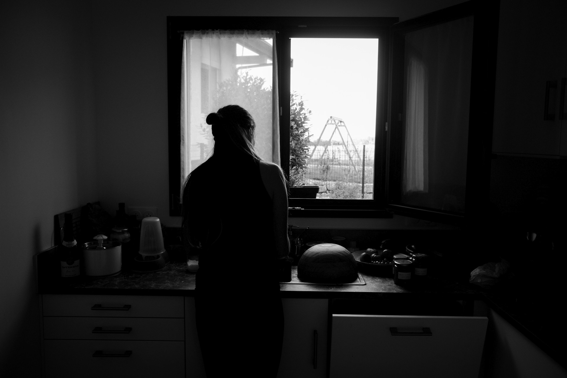Graustufenaufnahme einer Frau, die in der Küche steht | Quelle: Unsplash