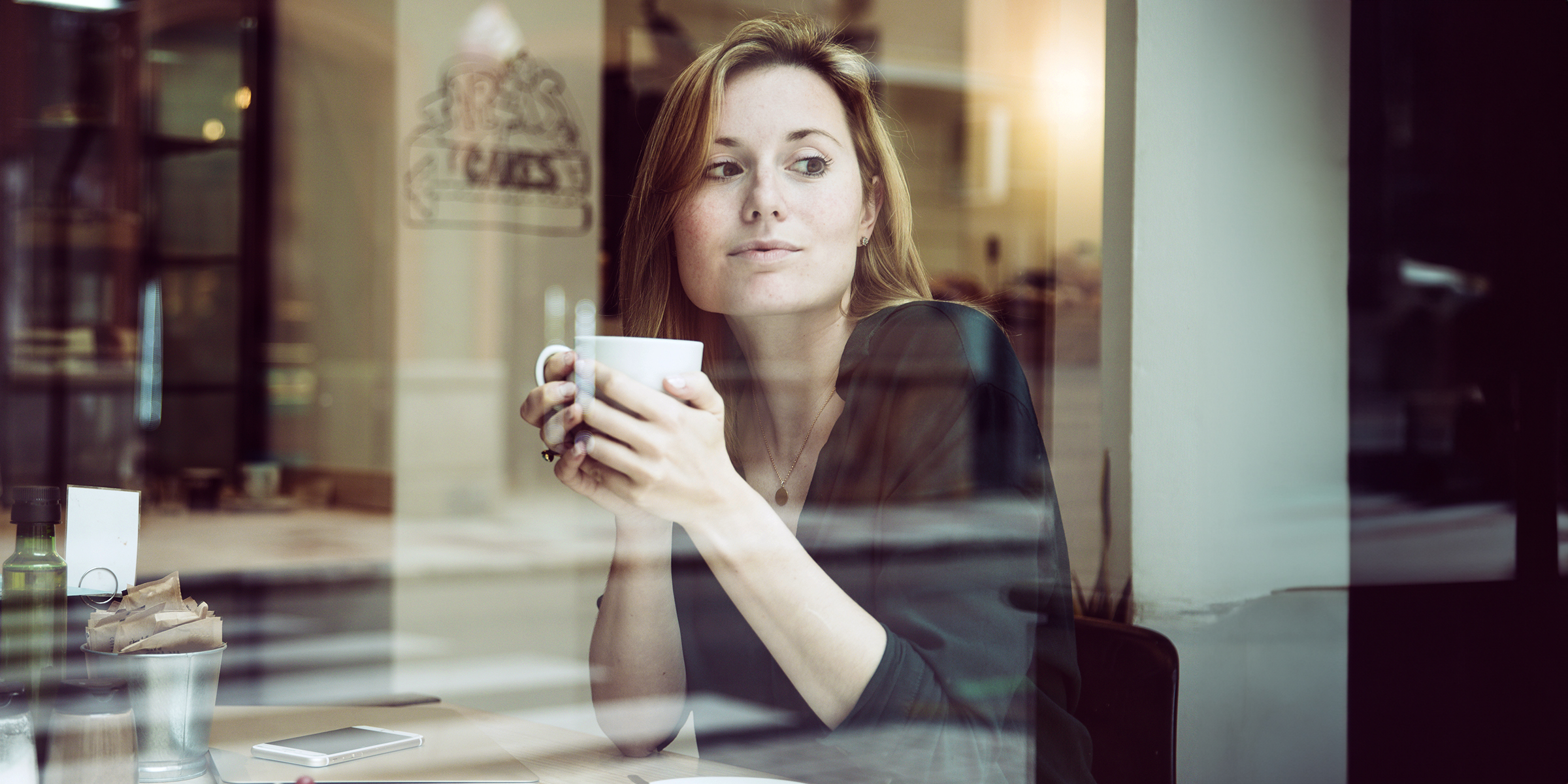 Eine Frau sitzt in einem Café | Quelle: freepik.com/freepik