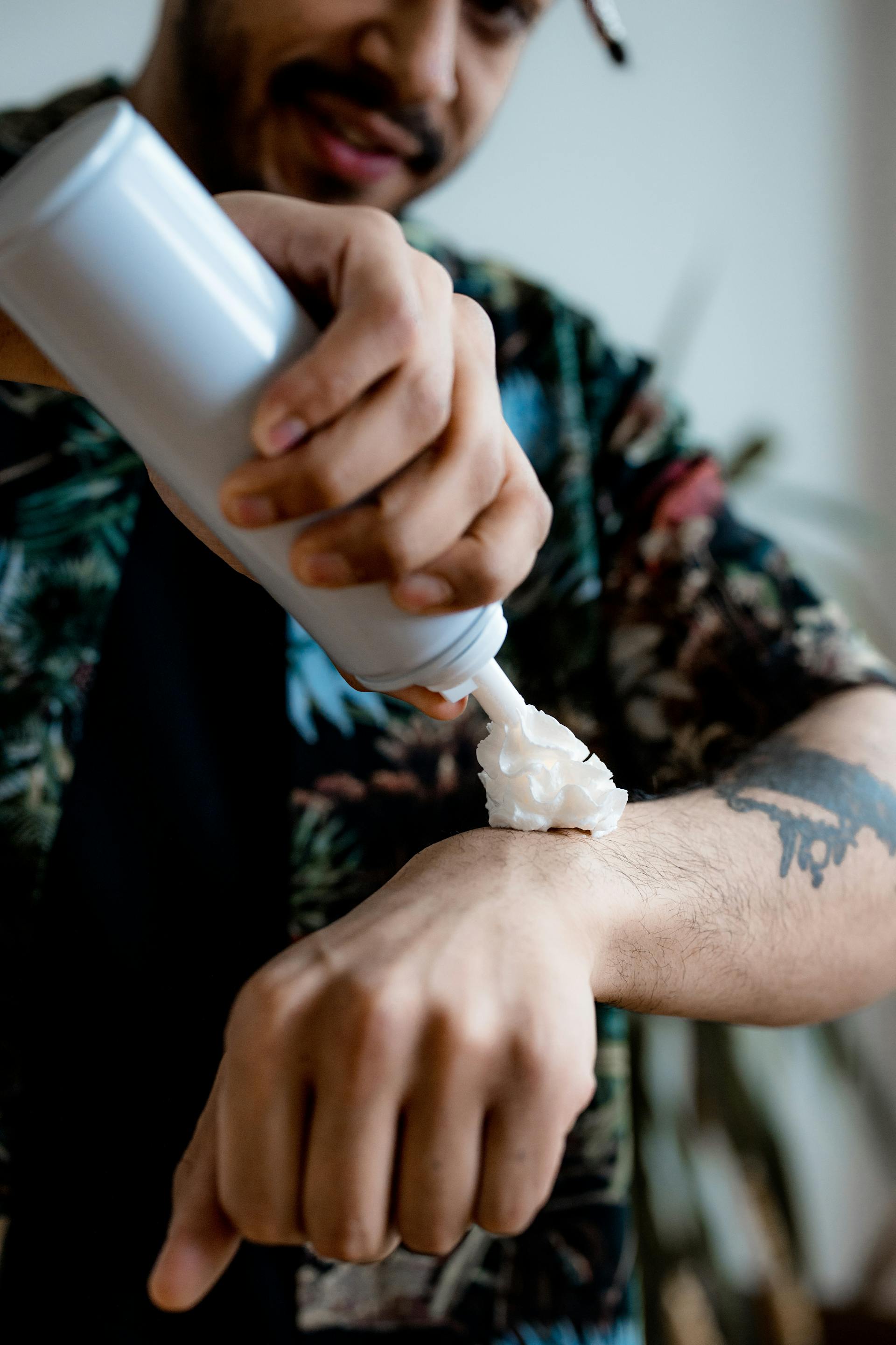 Ein Mann, der sich Schlagsahne auf seinen Arm spritzt | Quelle: Pexels
