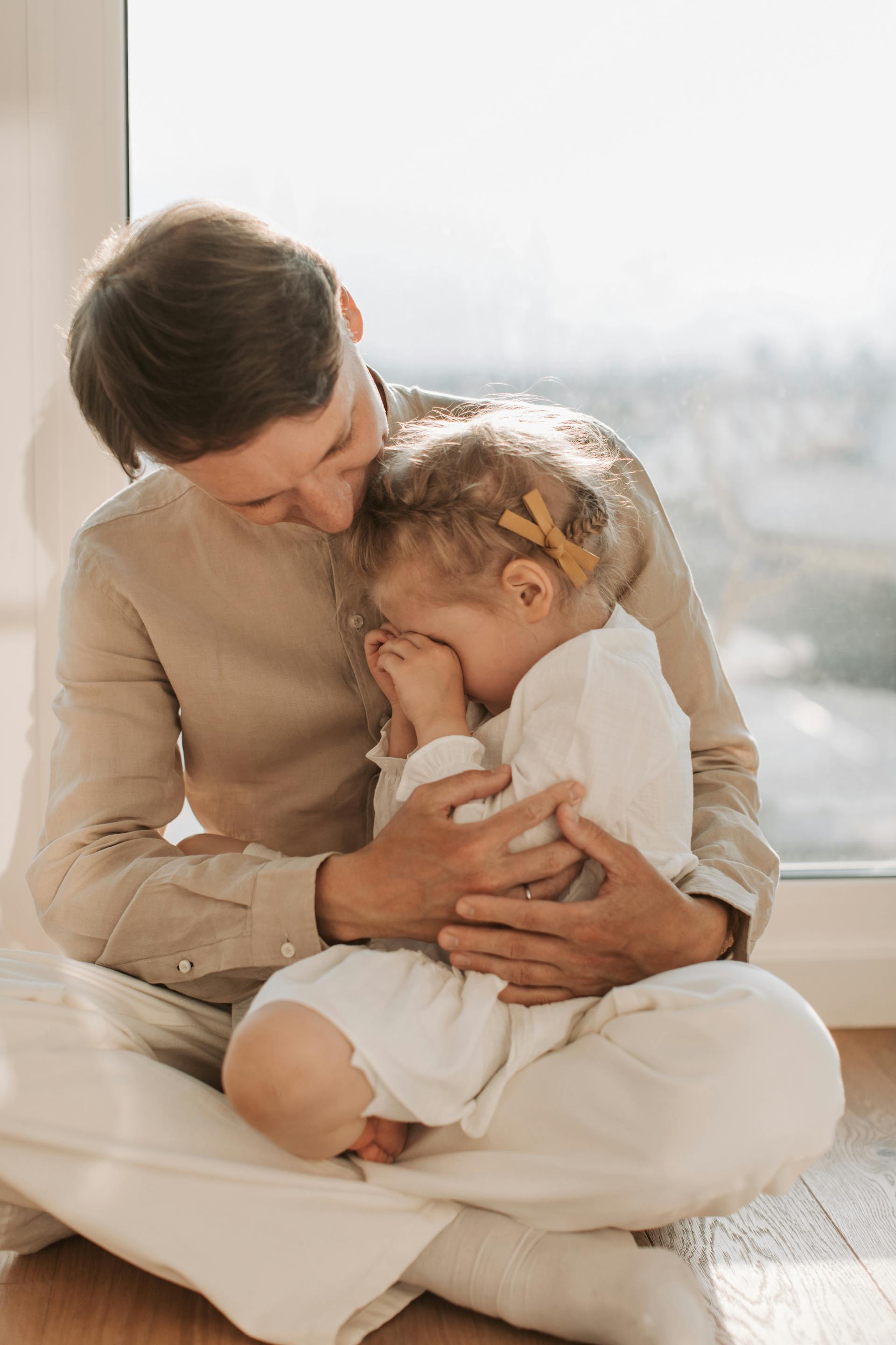 Ein Vater tröstet seine traurige kleine Tochter | Quelle: Pexels