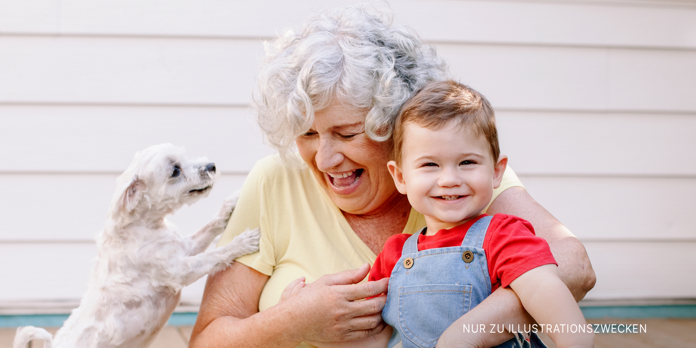 Eine Großmutter und ihr Enkelkind mit einem Welpen | Quelle: Shutterstock