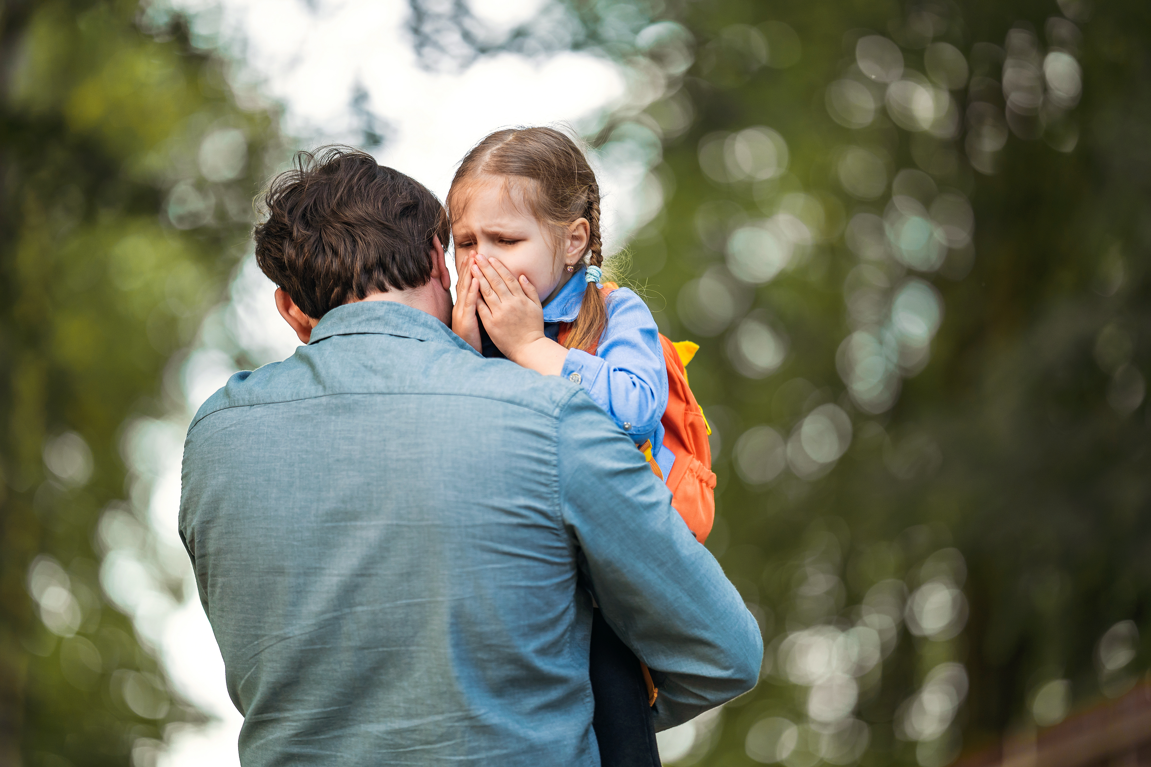 Ein Mann, der ein weinendes junges Mädchen im Arm hält | Quelle: Shutterstock