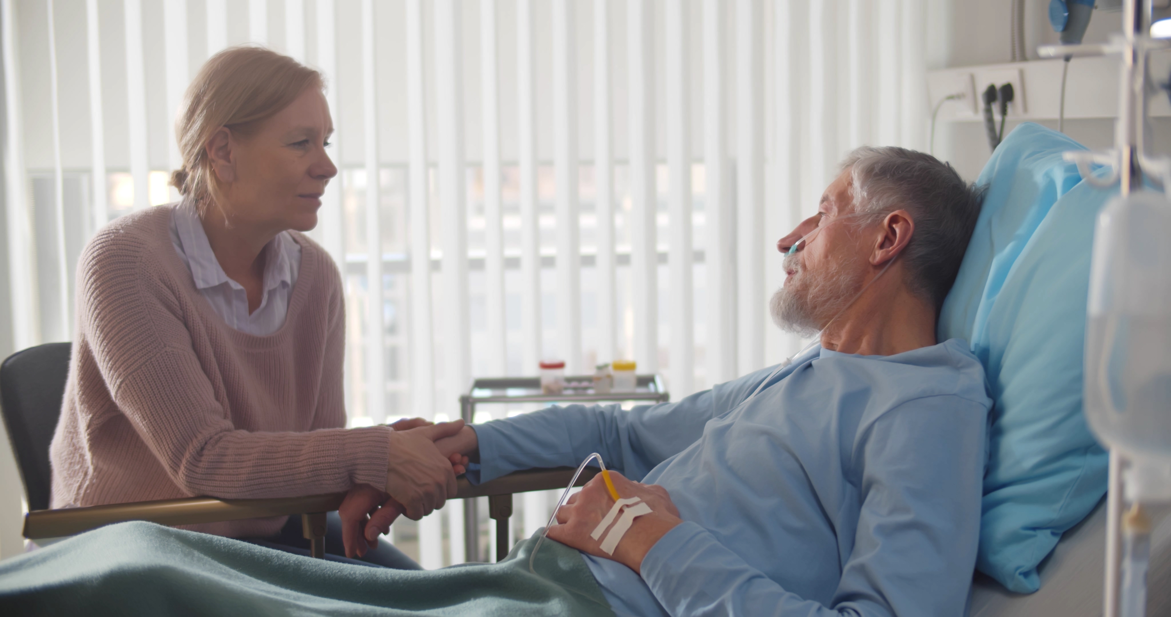 Eine ältere Frau tröstet ihren kranken Mann im Krankenhaus | Quelle: Shutterstock
