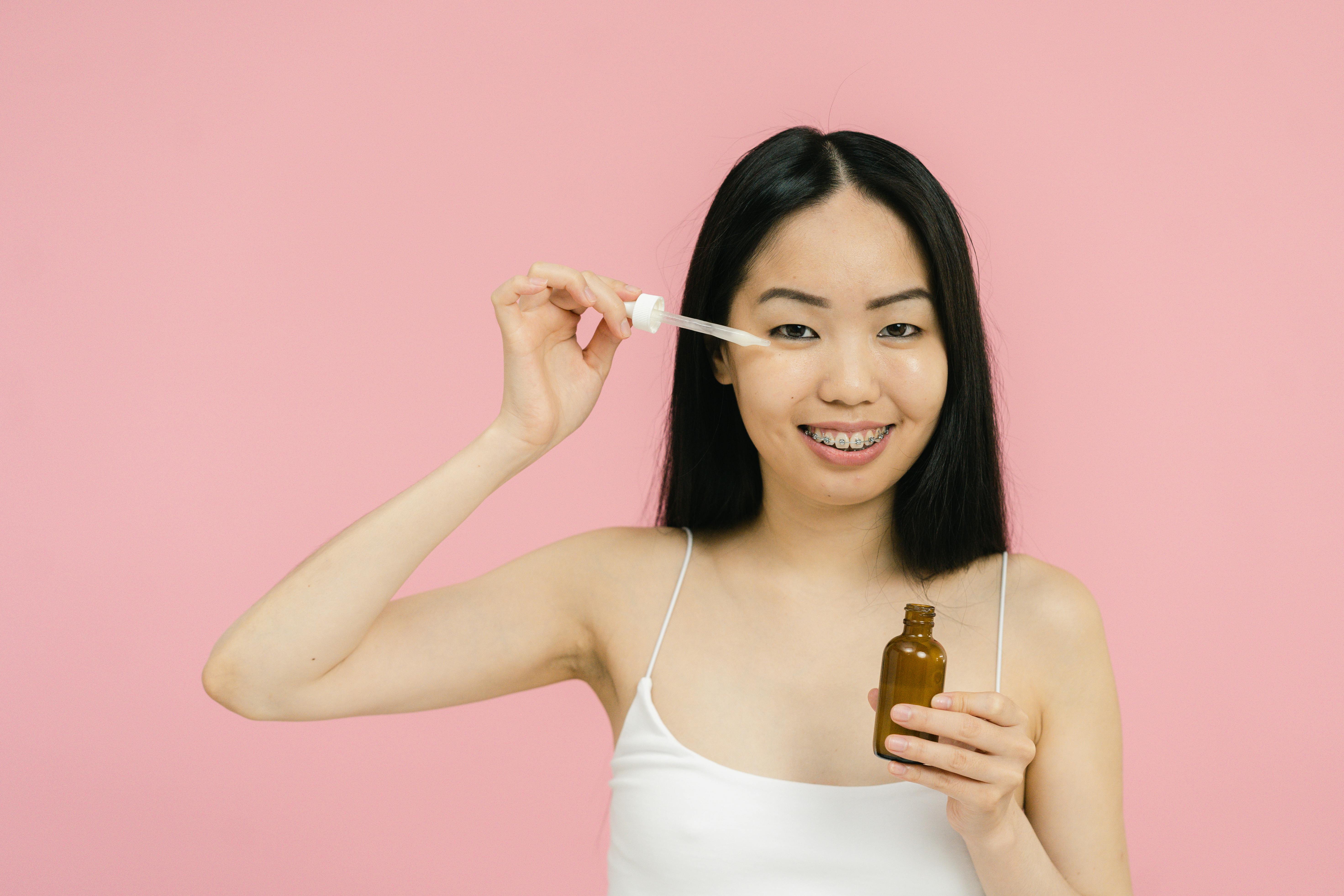Eine Frau trägt ein Serum auf ihr Gesicht auf | Quelle: Pexels