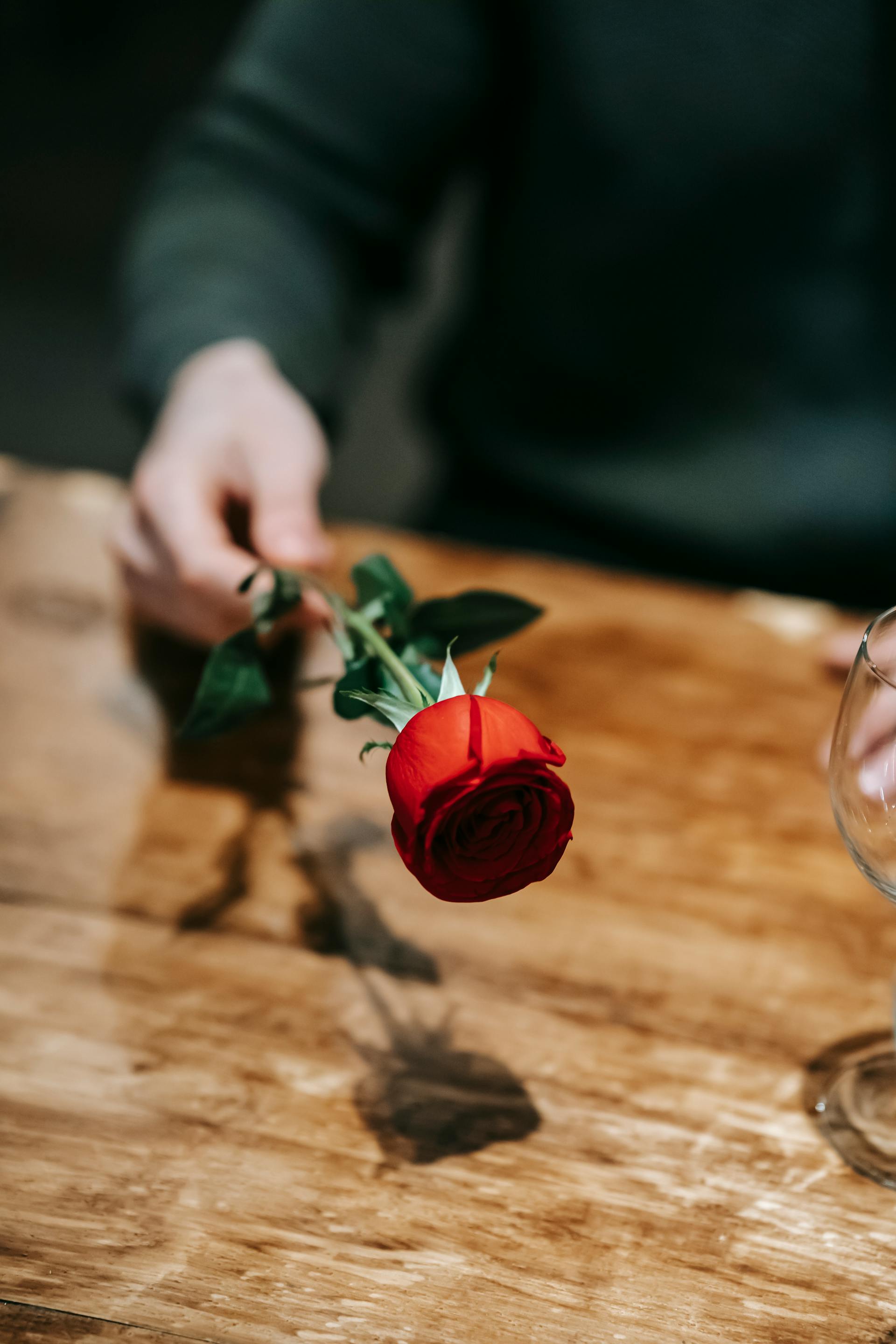 Ein Mann hält eine rote Rose | Quelle: Pexels