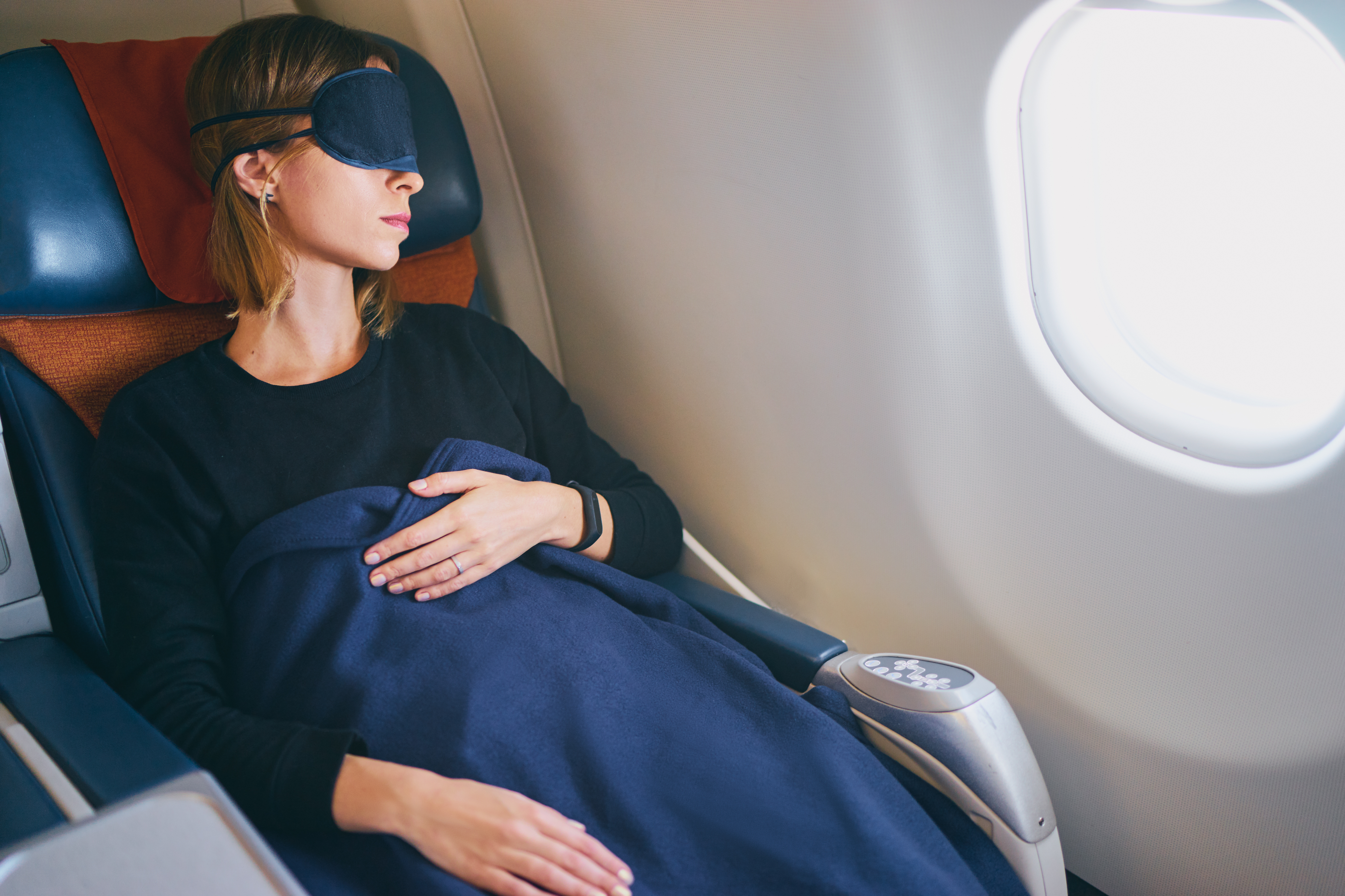 Eine schlafende Passagierin in einem Flugzeug | Quelle: Shutterstock