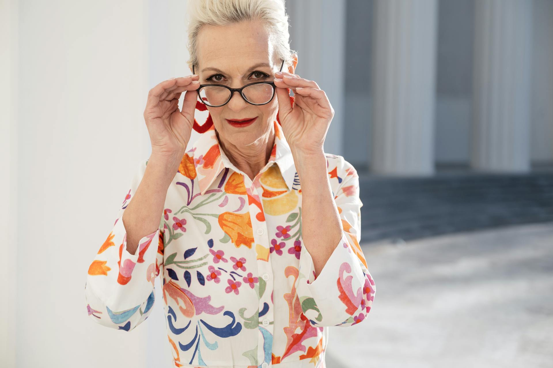 Eine ältere Frau hält ihre Brille | Quelle: Pexels