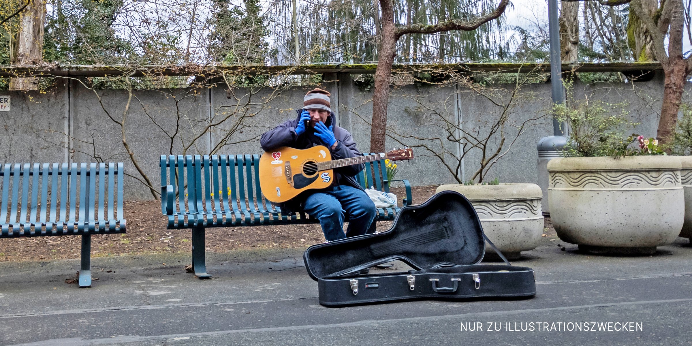 Mann spielt draußen Gitarre. | Quelle: Shutterstock