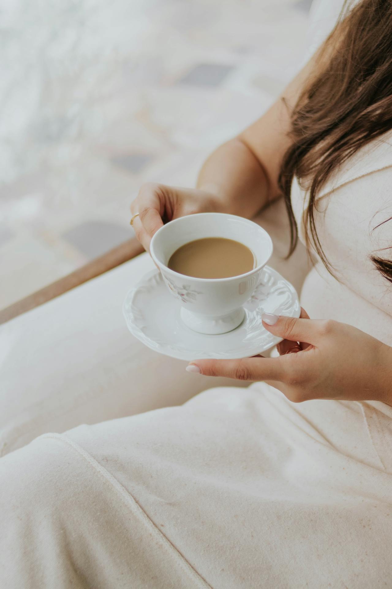 Eine Frau sitzt mit einer Tasse Kaffee | Quelle: Pexels