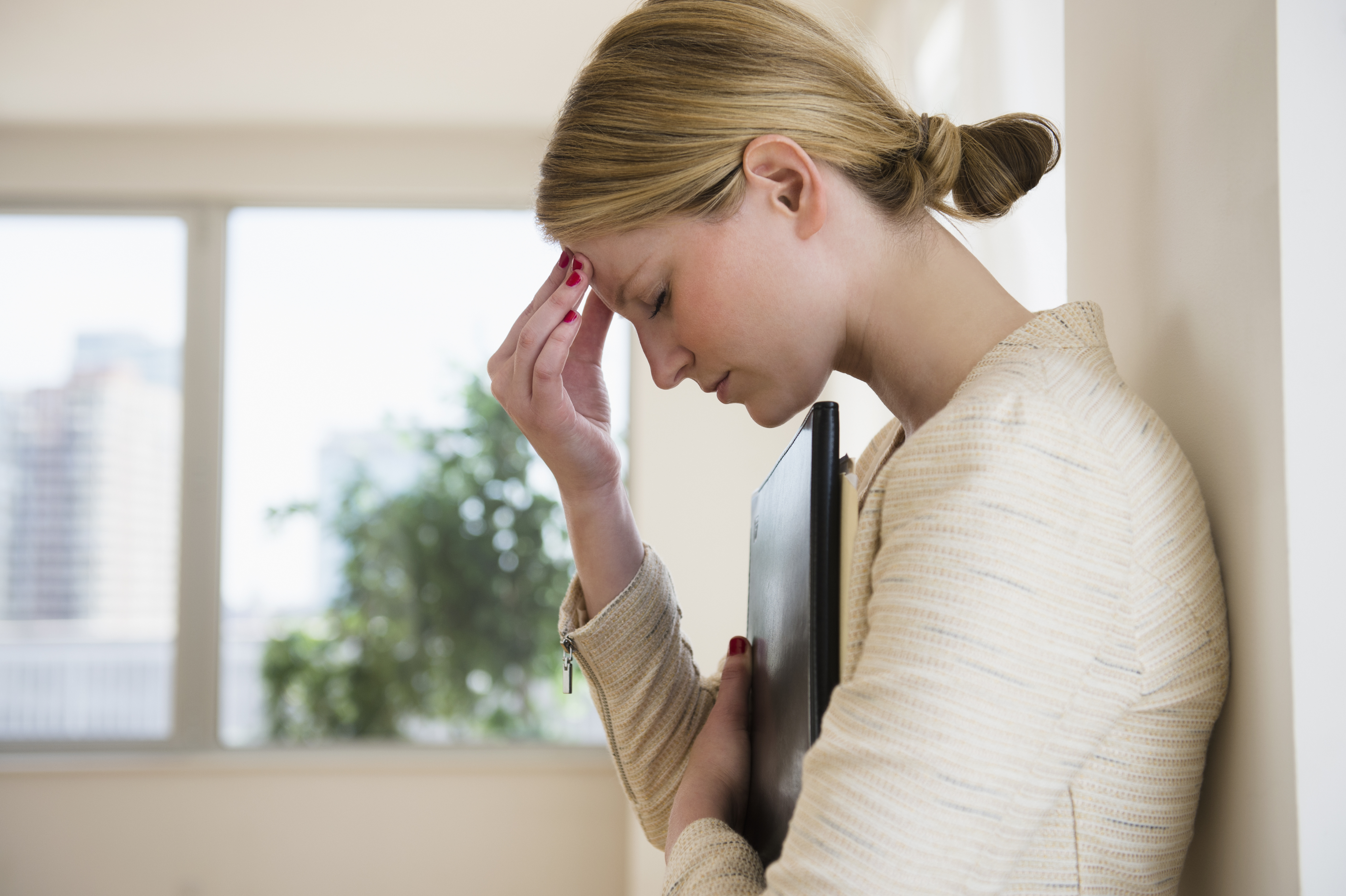 Geschäftsfrau mit Kopfschmerzen | Quelle: Getty Images
