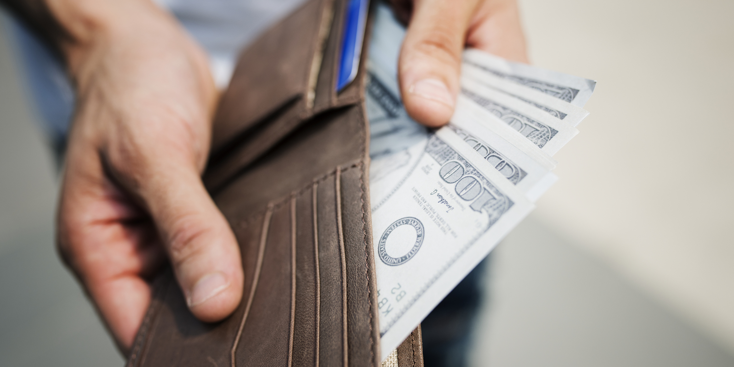 Eine Person, die Geld in ihre Brieftasche steckt | Quelle: Freepik