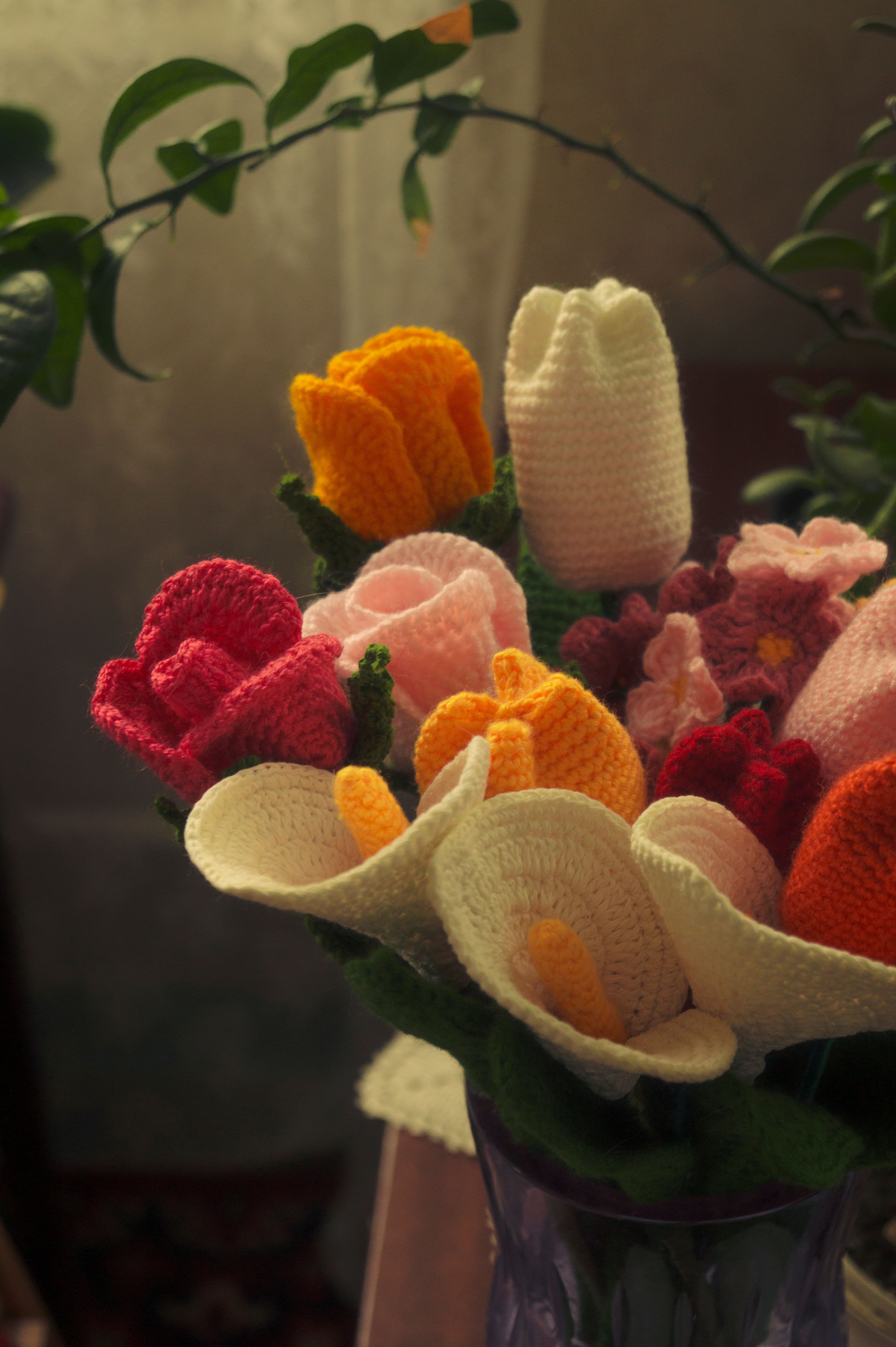 Ein farbenfroher Strauß aus gehäkelten Blumen in verschiedenen Farben, in einer Vase arrangiert | Quelle: Pexels