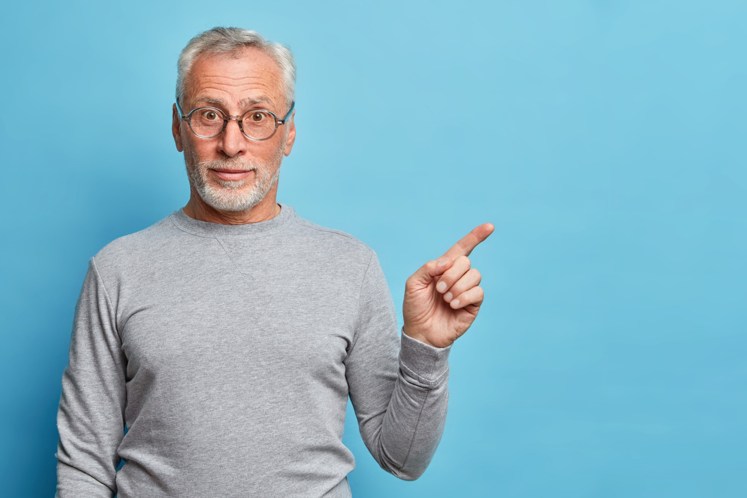 Ein lächelnder älterer Mann, der mit dem Finger zeigt | Quelle: Freepik