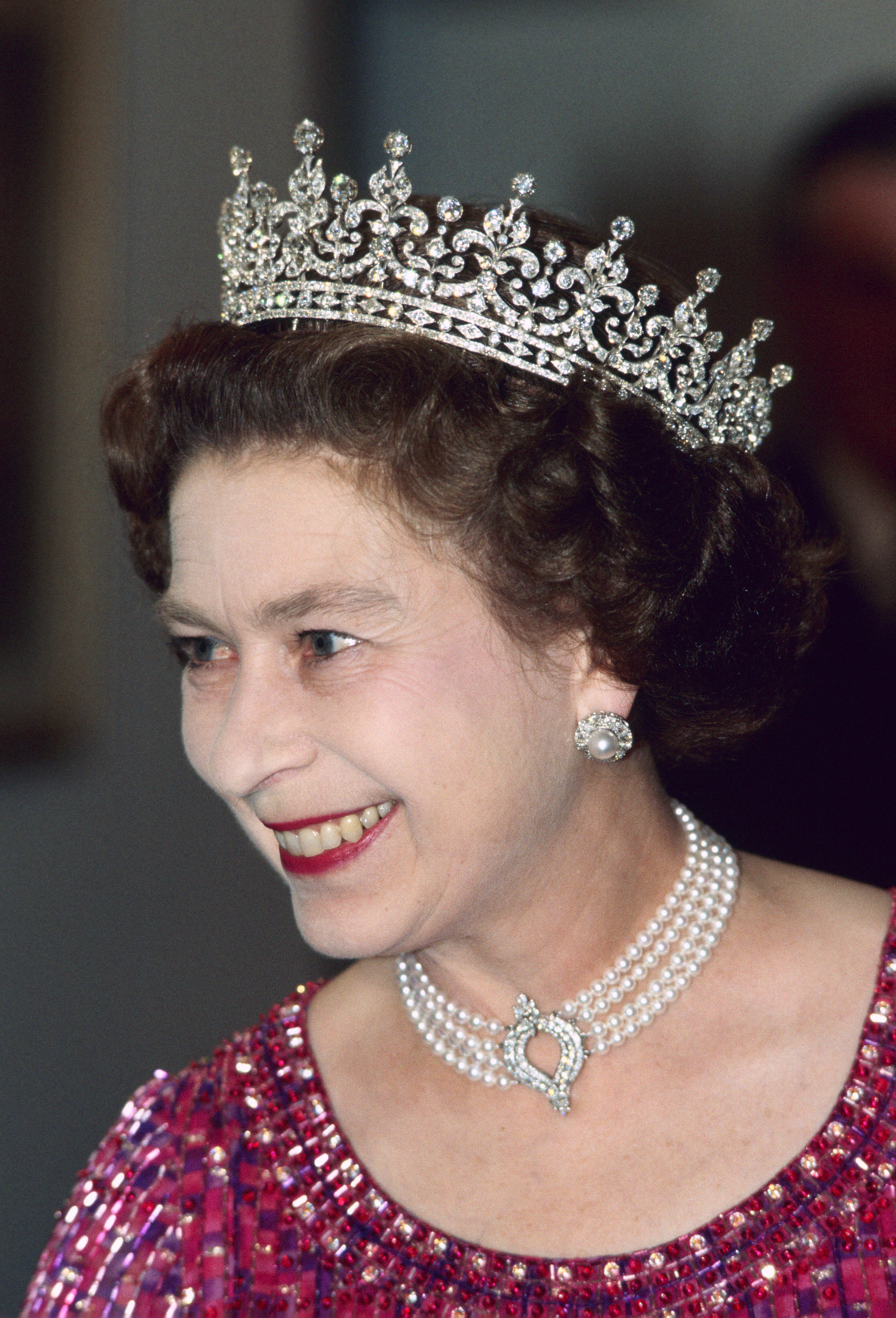 Königin Elizabeth II. trägt bei einer Verlobung in Bangladesch am 16. November 1983 ein vierreihiges Diamant- und Perlenhalsband mit einem Tiara | Quelle: Getty Images