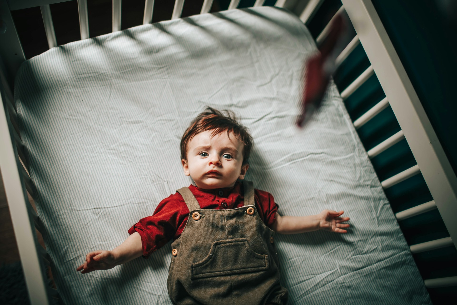 Ein kleiner Junge in einem Kinderbett | Quelle: Unsplash