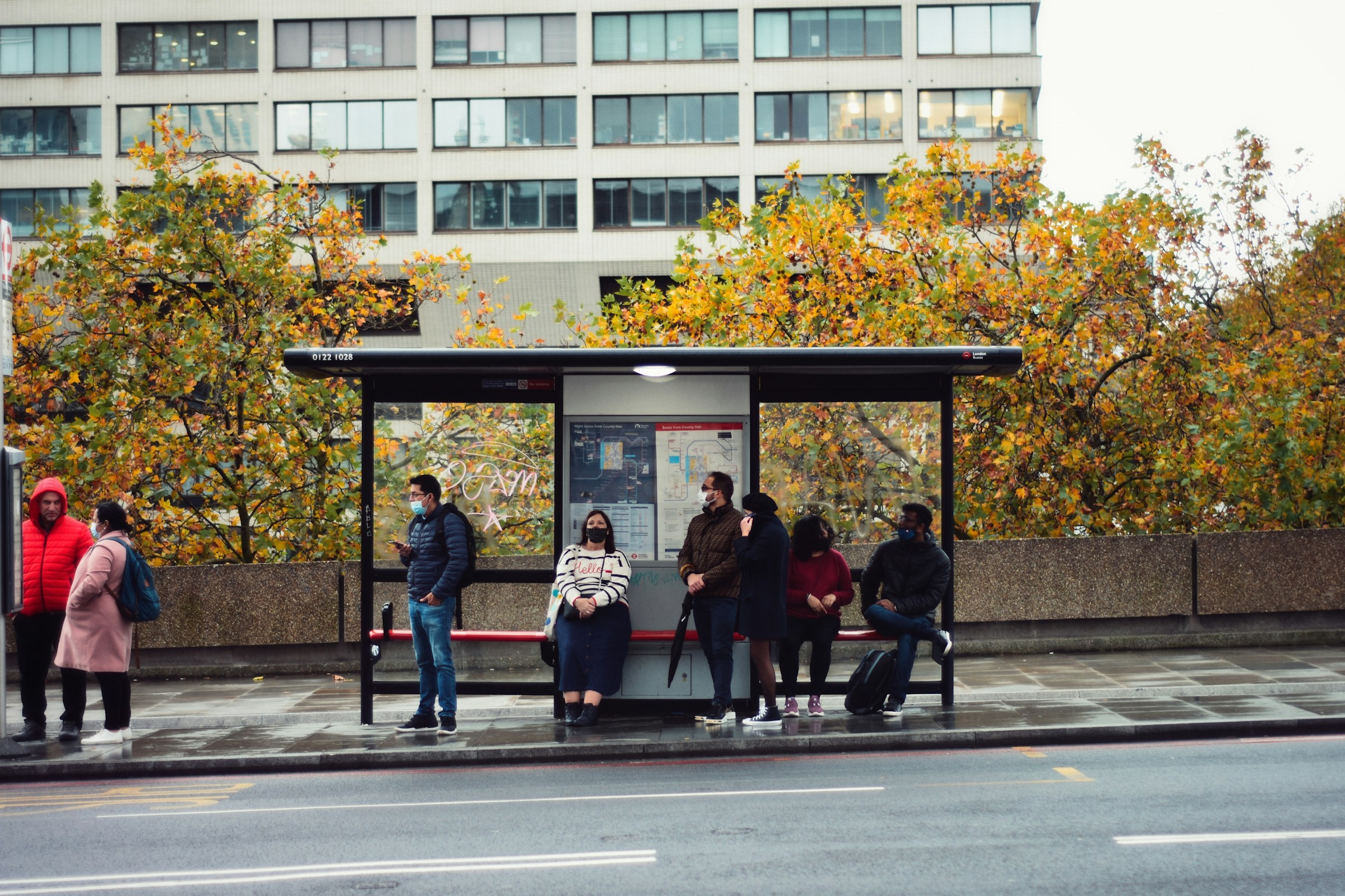 Menschen, die an einer Bushaltestelle auf den Bus warten | Quelle: Unsplash