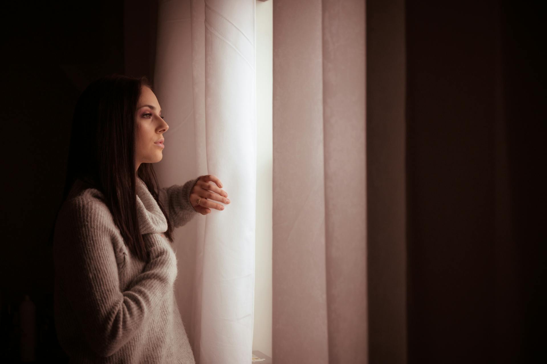 Eine nachdenkliche Frau, die aus einem Fenster starrt | Quelle: Pexels