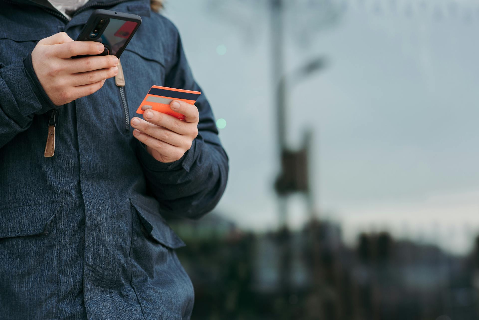 Ein Mann hält seine Karte und sein Telefon | Quelle: Pexels